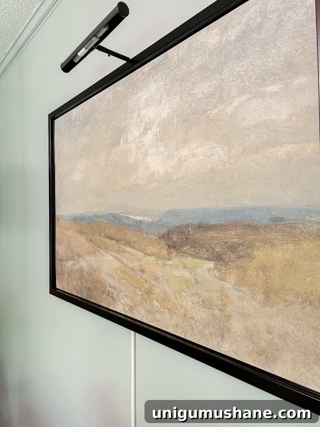 Install a Plug-In Picture Light Without Hardwiring 6 art light above art with cord stuck to wall below