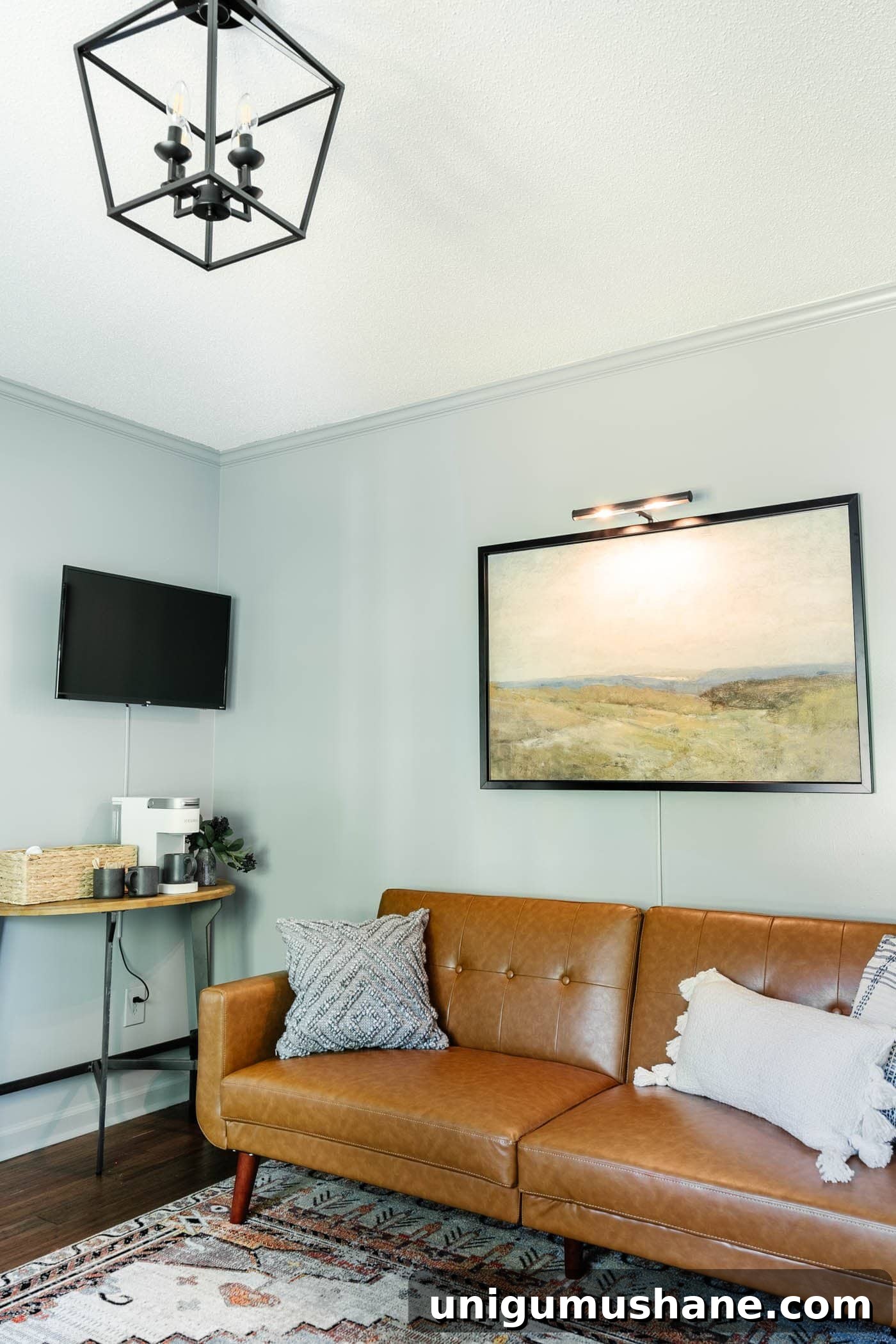 Install a Plug-In Picture Light Without Hardwiring 7 art with picture light above a home office lounge sofa with coffee bar table and TV