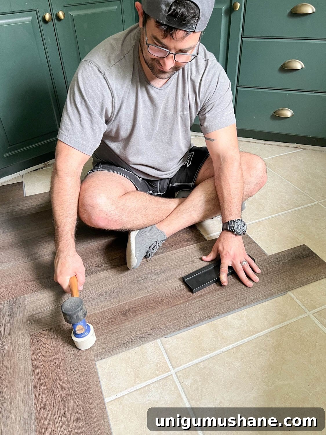 using a mallet to click LVP flooring into place during installation