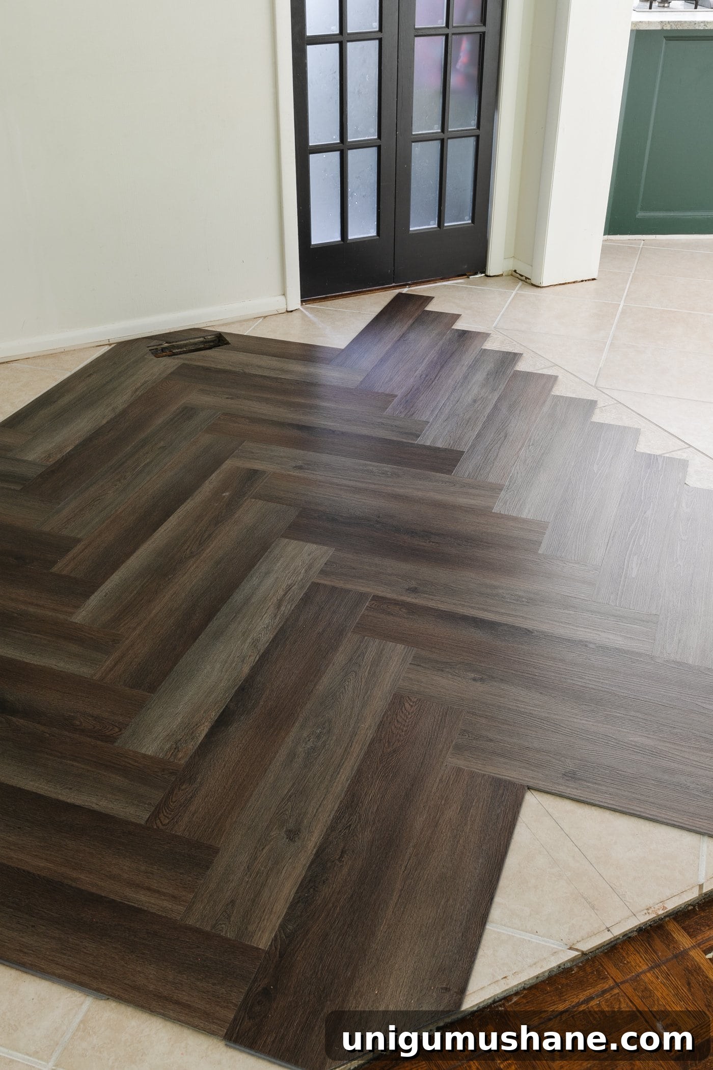 brown herringbone LVP floating floor over tile in a kitchen