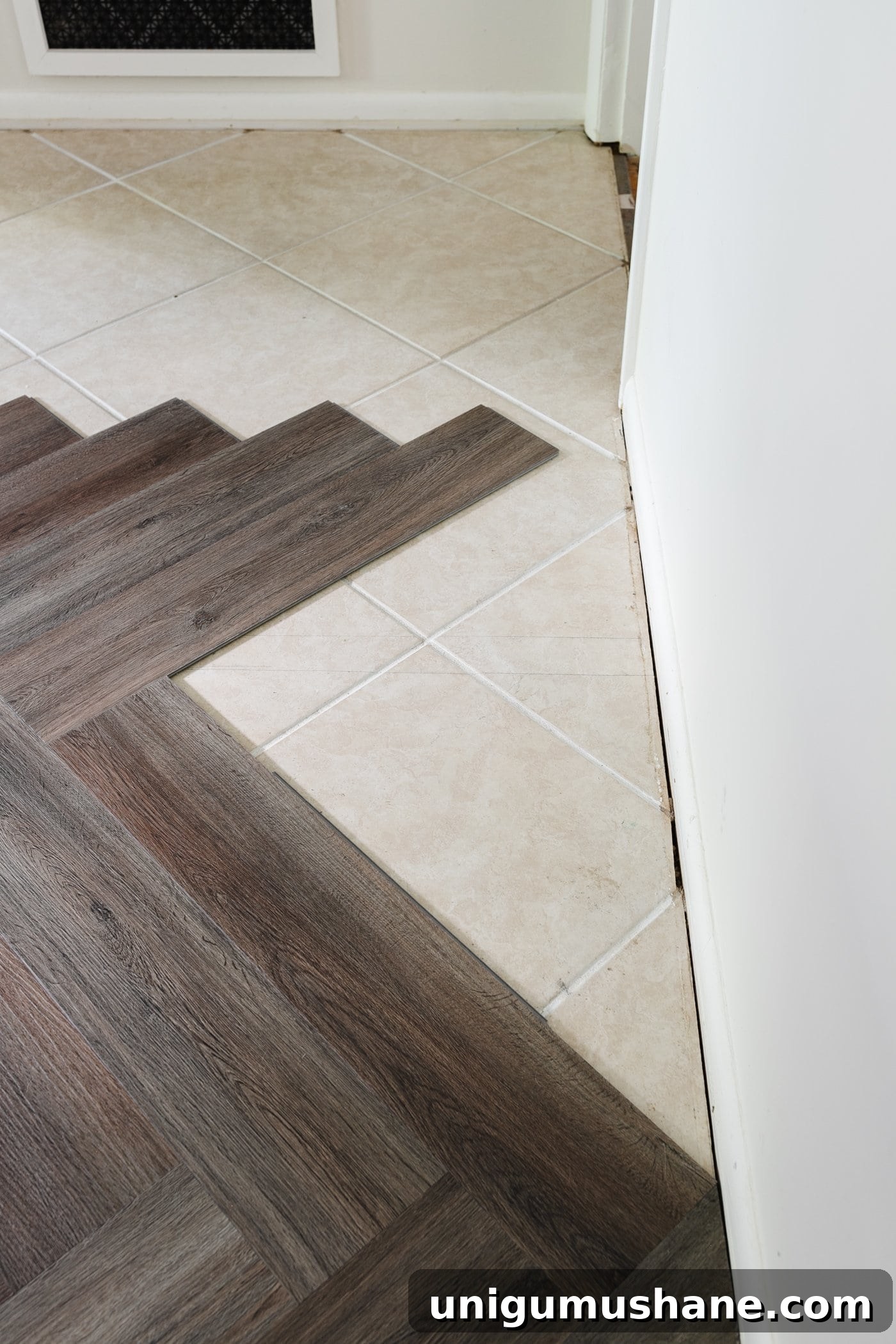 finishing a row of herringbone LVP flooring against a wall