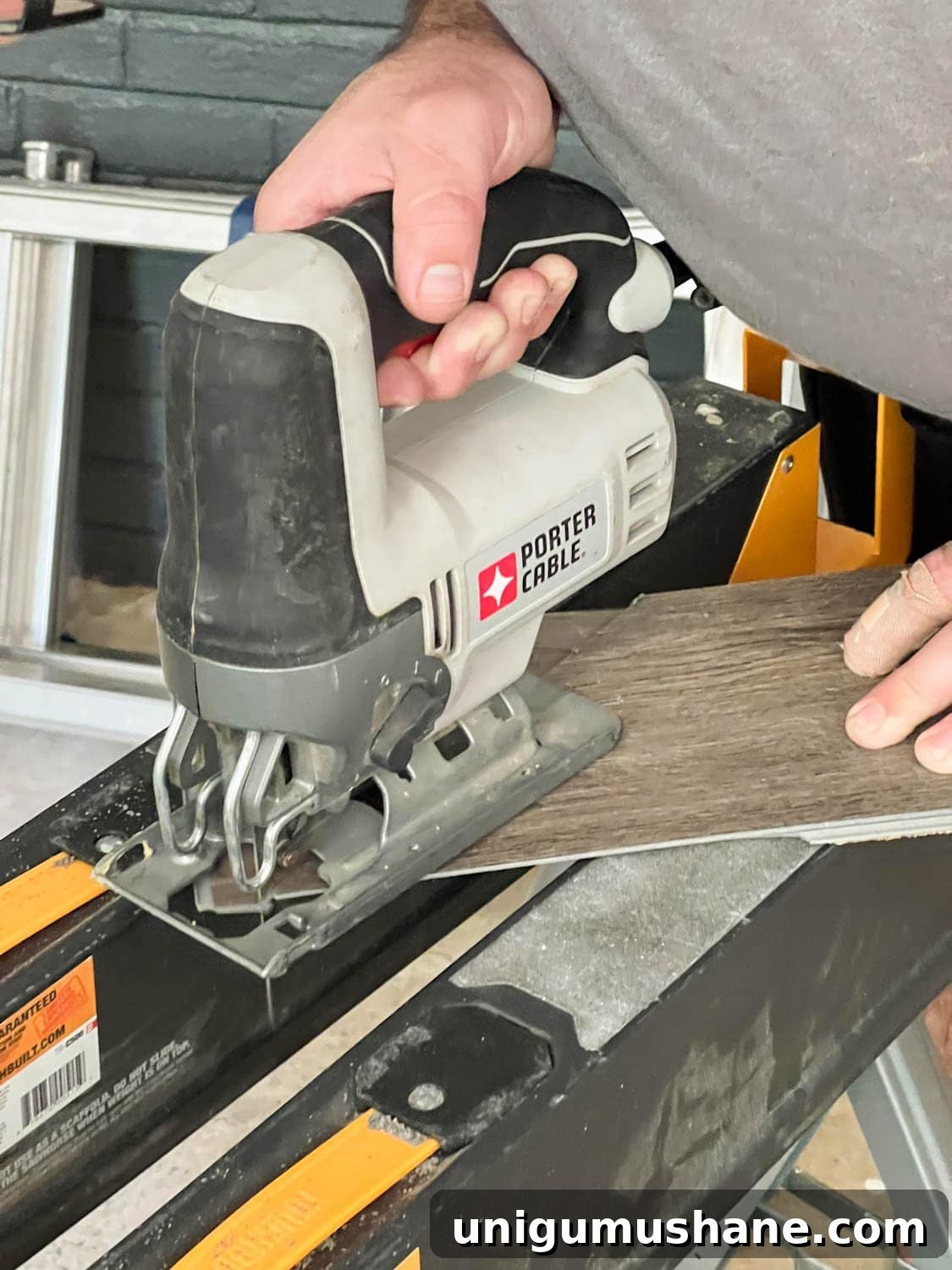 cutting a piece of LVP flooring with a jigsaw and a carbide blade