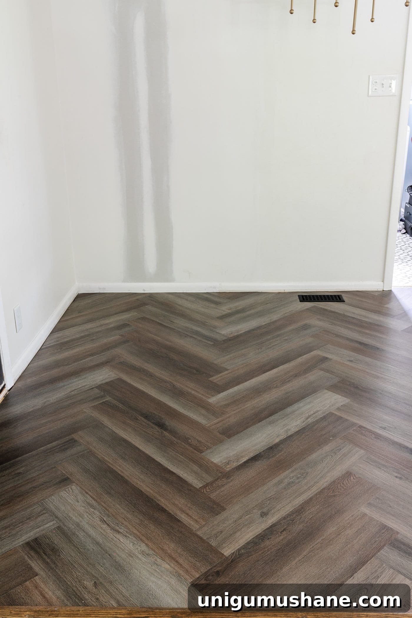 finished herringbone LVP floating floor over tile in a kitchen