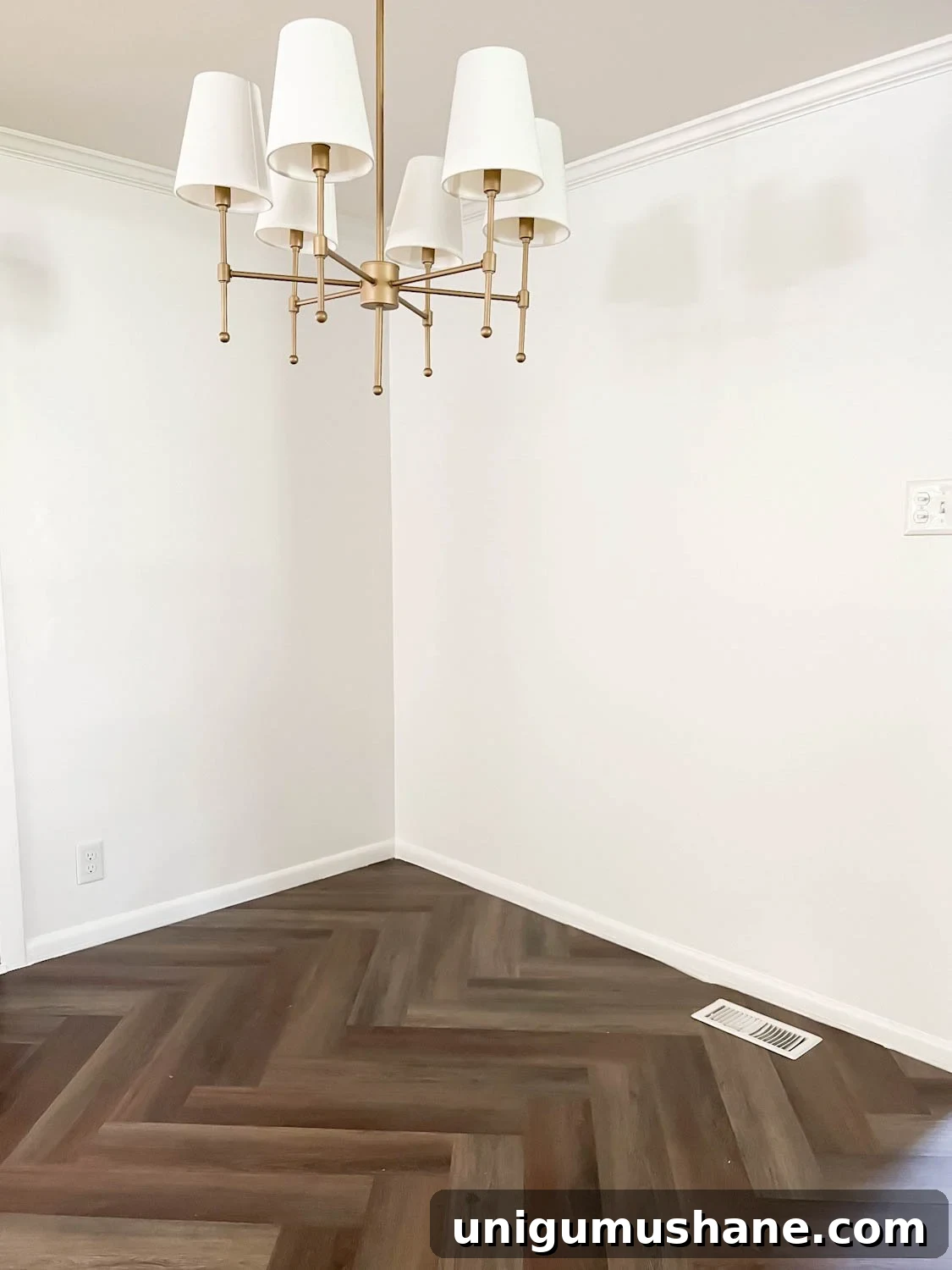 Transform Corner Banquette and Redirect Under Cabinet Air Vents 4 corner of breakfast nook with chandelier, white walls, and herringbone floor with a floor vent