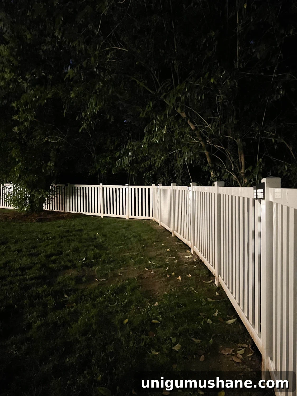 Backyard Lighting Ideas You Can Install Yourself 11 solar step lights attached to fence posts lit up at night in a backyard