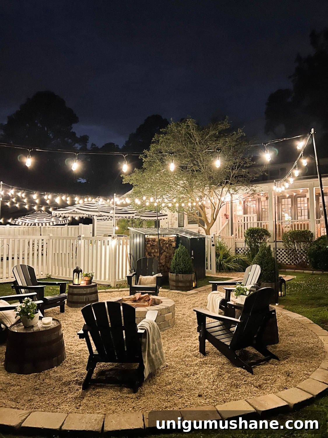Backyard Lighting Ideas You Can Install Yourself 14 fire pit string lights with pea gravel, black Adirondack chairs, and wood shed in a backyard