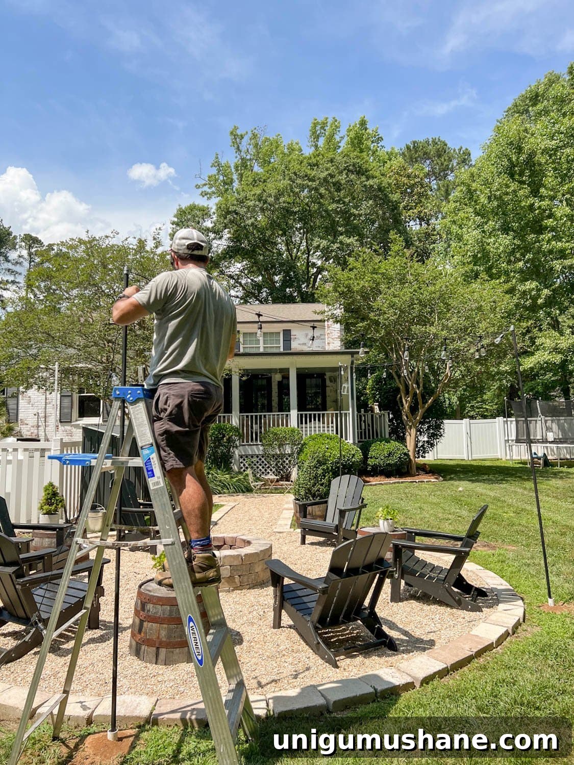 How to Hang Outdoor String Lights Anywhere in Your Backyard 21 attaching string lights to cable around a fire pit