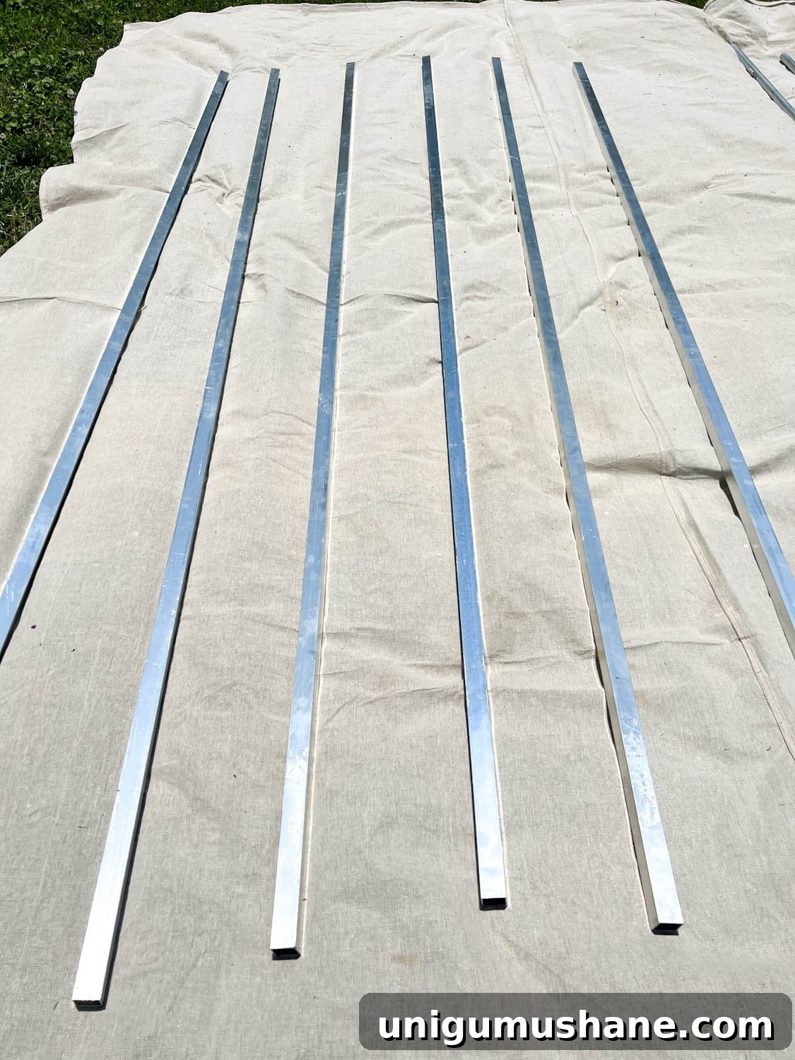 How to Hang Outdoor String Lights Anywhere in Your Backyard 25 square aluminum tubing on a drop cloth to be painted