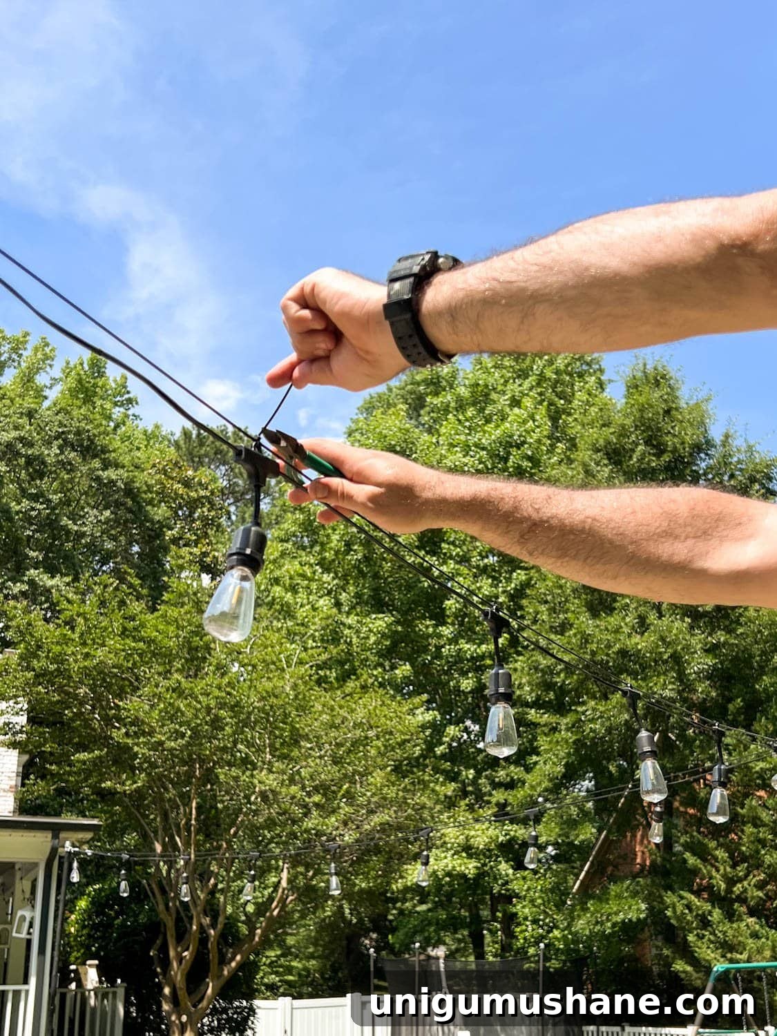 How to Hang Outdoor String Lights Anywhere in Your Backyard 31 snipping zip tie ends to attach string lights to cable