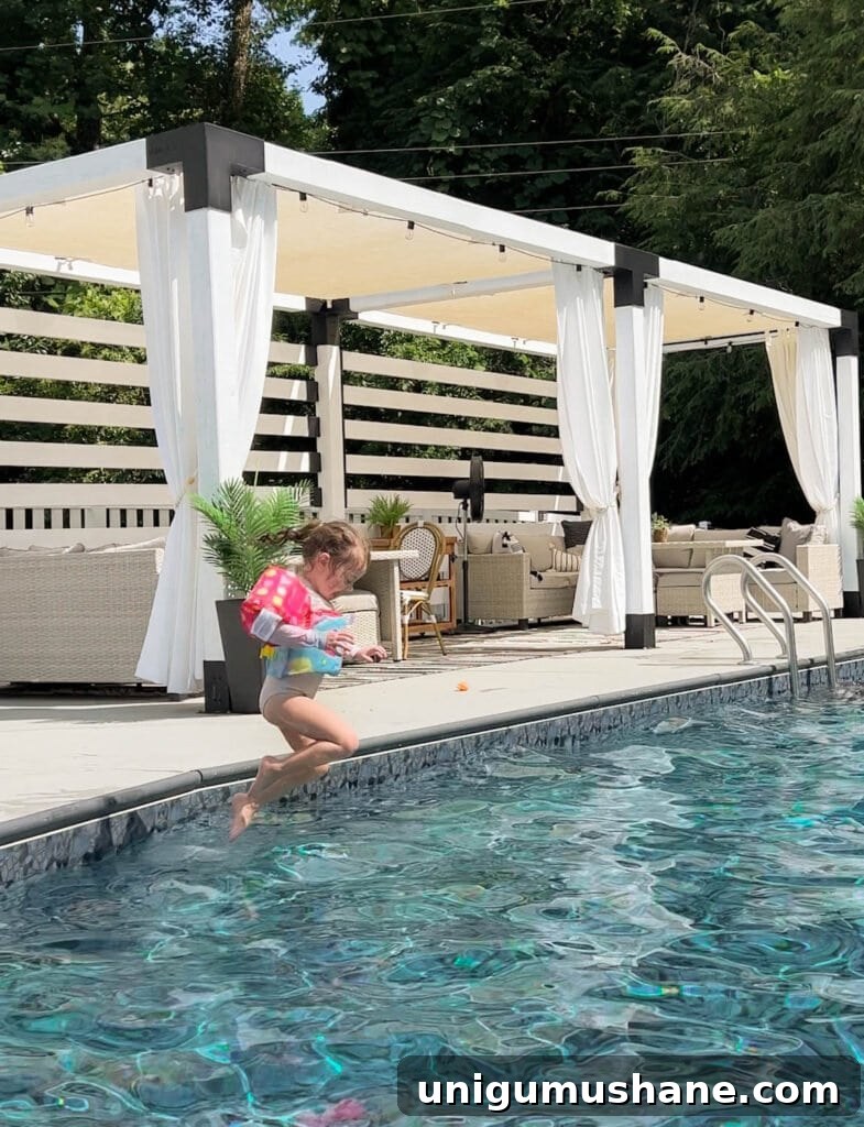 Must-Have Pool Toys for Kids and Adults This Summer 14 toddler girl jumping into a backyard swimming pool with a vest