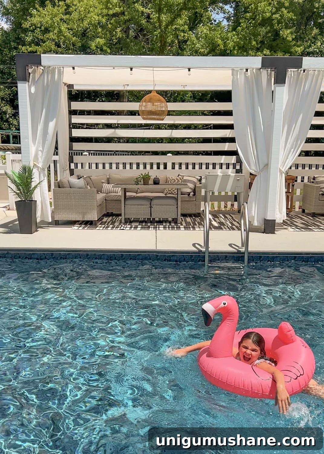Must-Have Pool Toys for Kids and Adults This Summer 20 little girl playing on a flamingo pool float tube in the water in front of a cabana