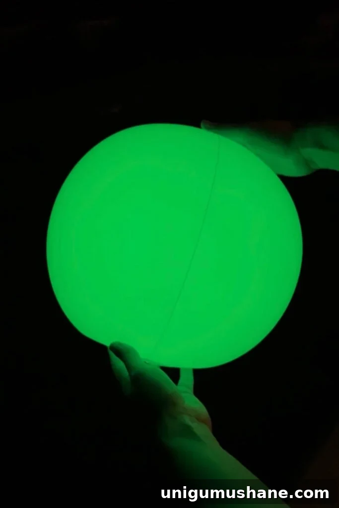 Must-Have Pool Toys for Kids and Adults This Summer 5 light up beach ball glowing green at night