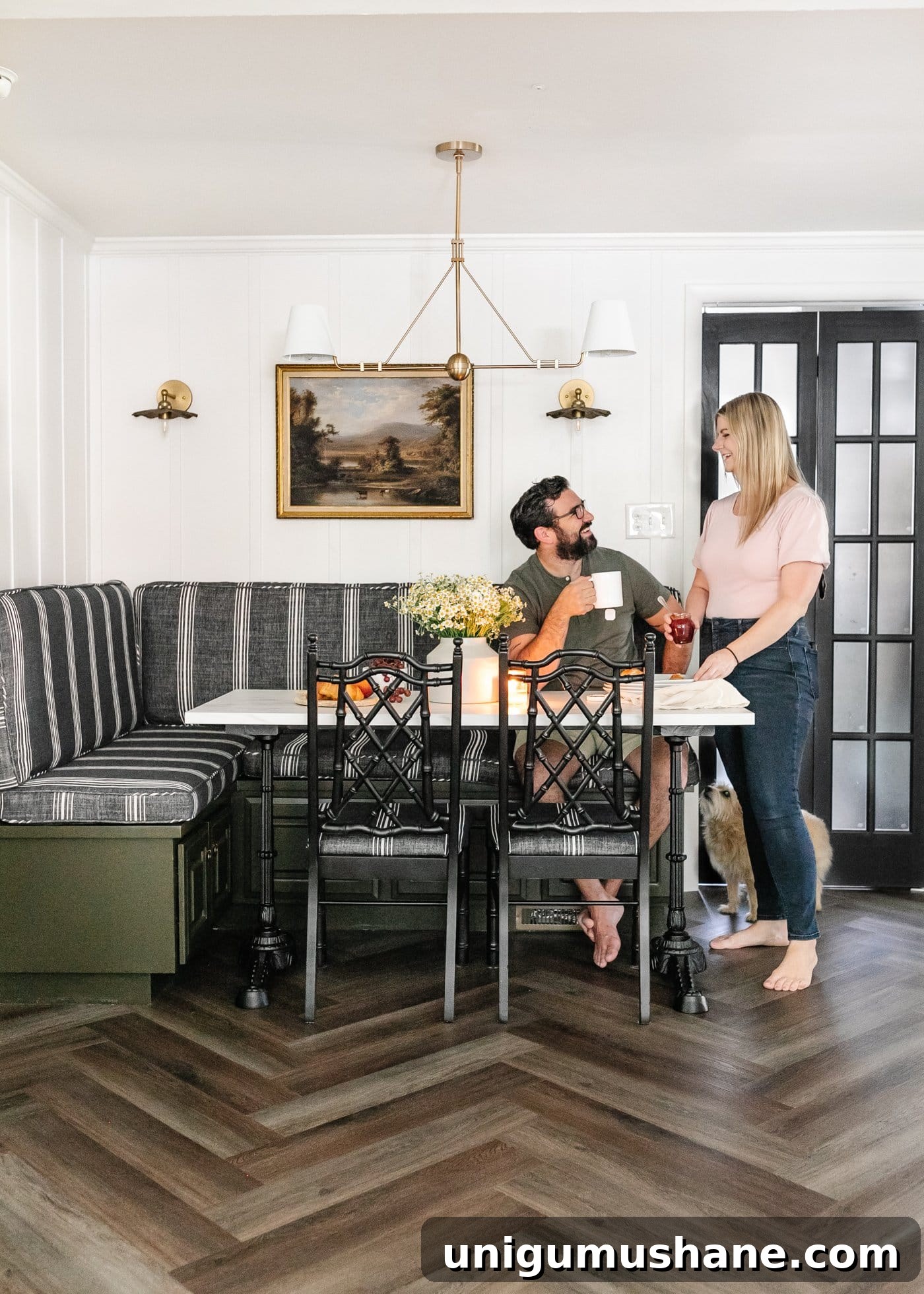 styled breakfast nook with striped banquette bench, marble table, and herringbone LVP floors from ProCore Floors
