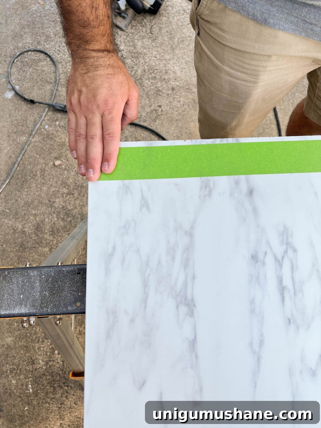 putting masking tape on laminate faux marble countertop to be cut