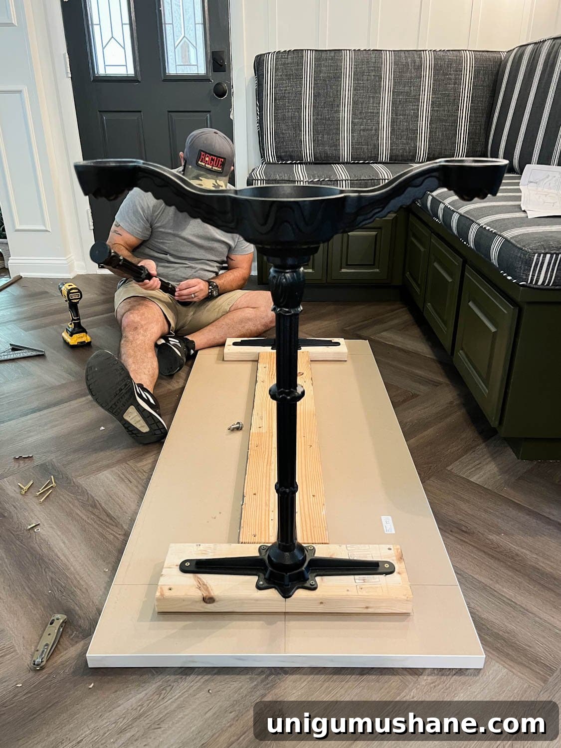 attaching 2x6 boards and cast iron pedestal legs underneath a countertop to make a faux marble dining table
