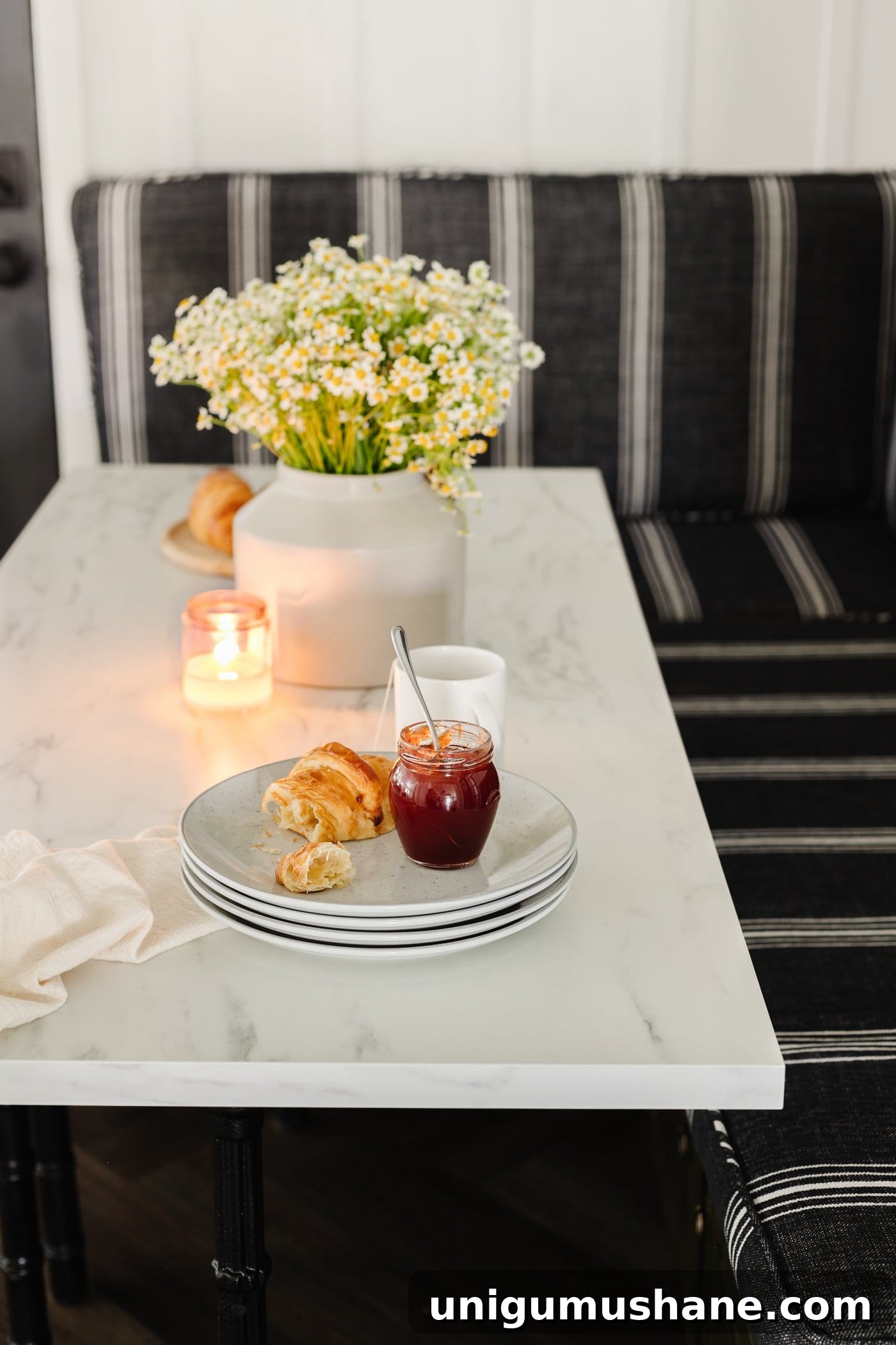 Parisian Bistro-Inspired Breakfast Nook Decor Ideas 12 marble dining table top with plates stacked and vase of daisy flowers