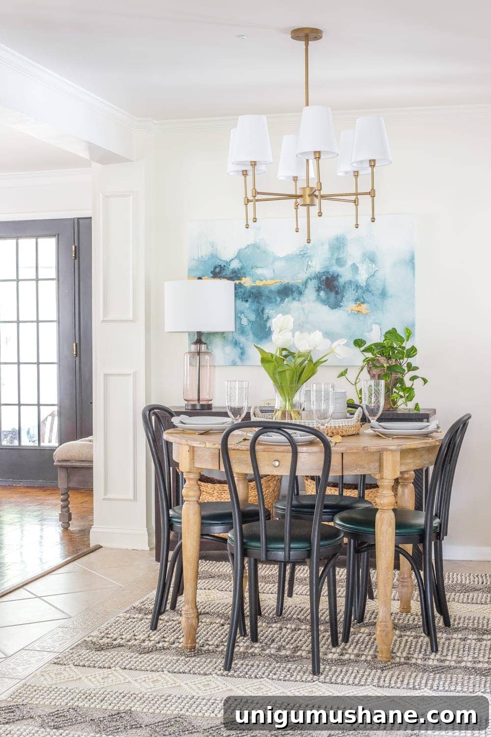 Parisian Bistro-Inspired Breakfast Nook Decor Ideas 20 small dining room with black bentwood chairs, wood dining table, blue watercolor art, and brass shaded chandelier
