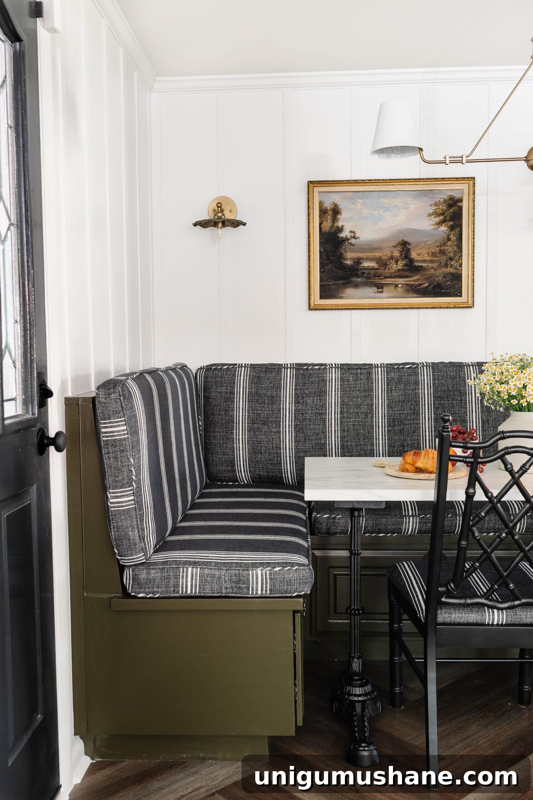 Parisian Bistro-Inspired Breakfast Nook Decor Ideas 8 striped charcoal cushions on a banquette bench painted olive green with white batten walls and an antique landscape oil painting