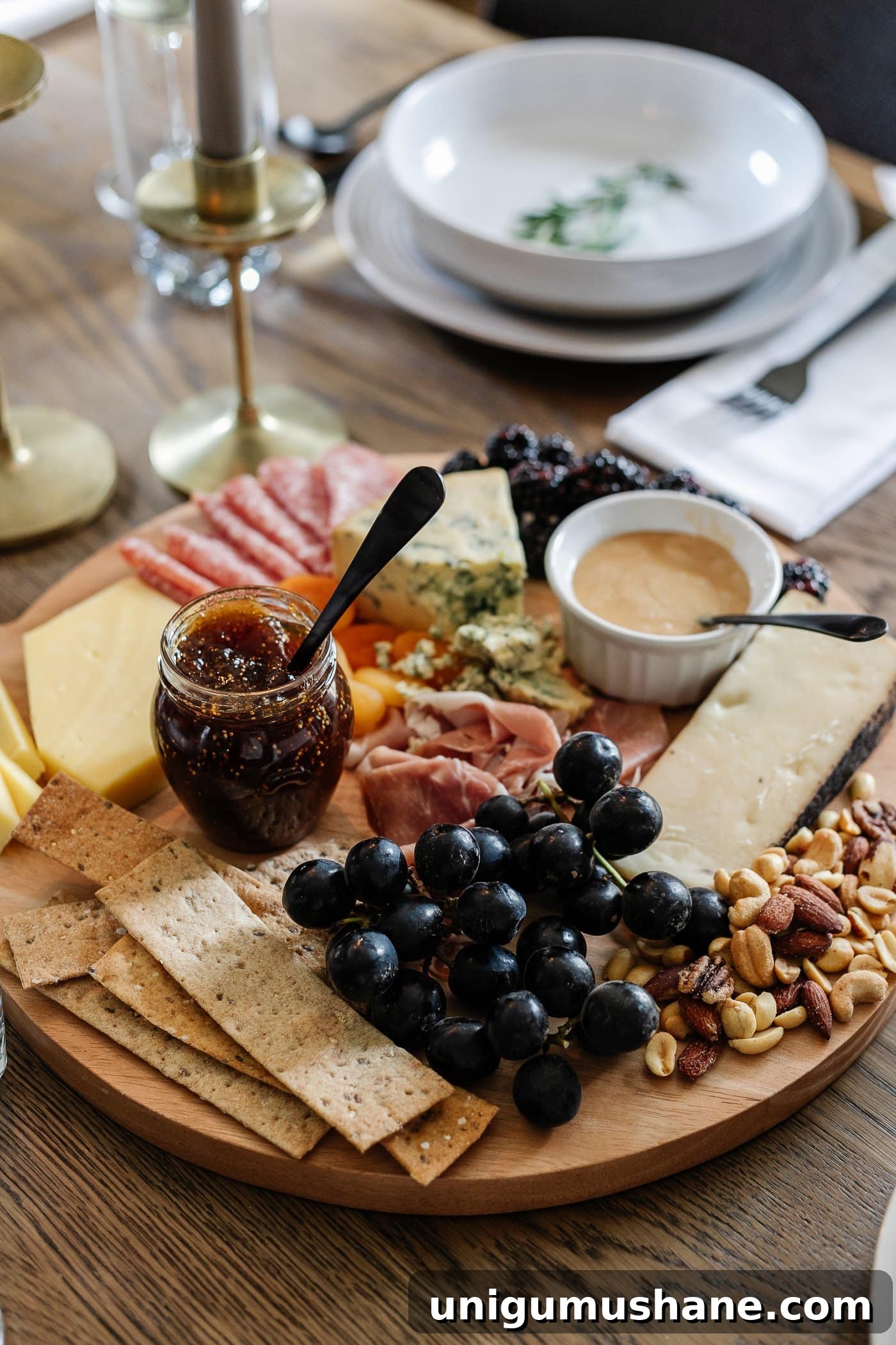 How to Set an Elegant Dinner Table for Any Occasion 15 charcuterie board with meats, cheeses, crackers, jams, fruit, nuts, and honey