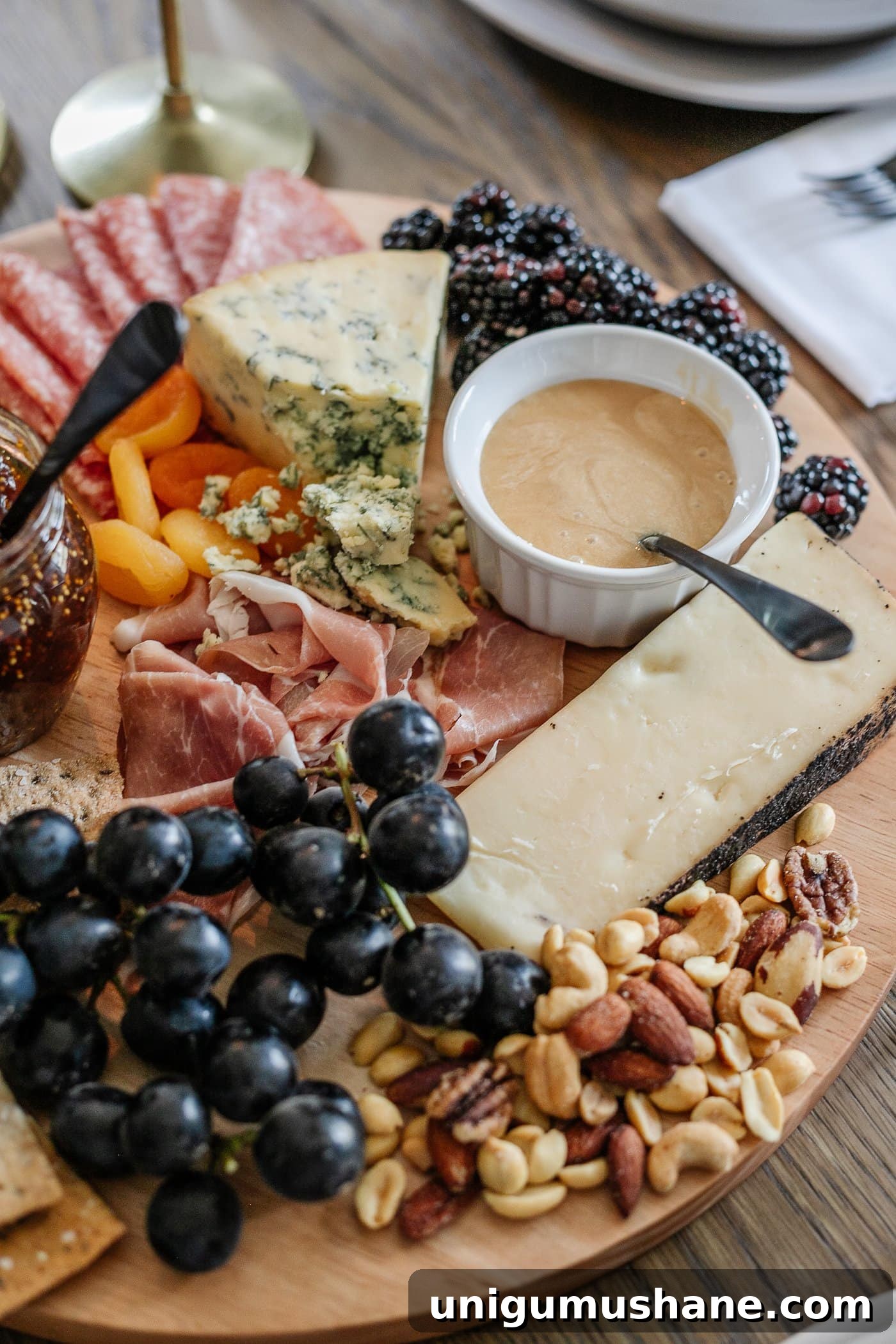 How to Set an Elegant Dinner Table for Any Occasion 16 charcuterie board with meats, cheeses, crackers, jams, fruit, nuts, and honey