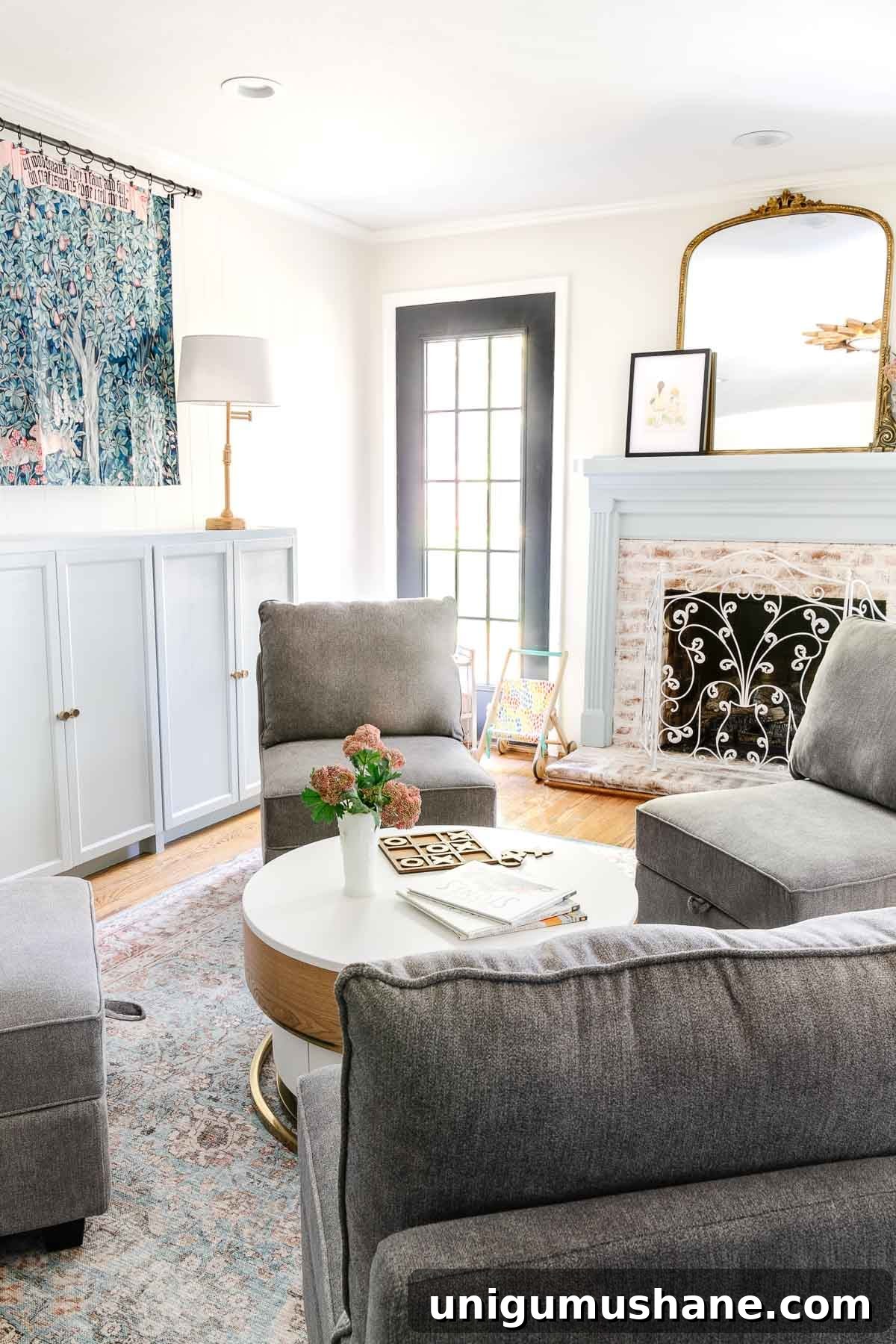 5-Year Home Transformation: Before and After Tour 26 white playroom with light blue mantel and toy storage cabinets, William Morris tapestry, and storage furniture