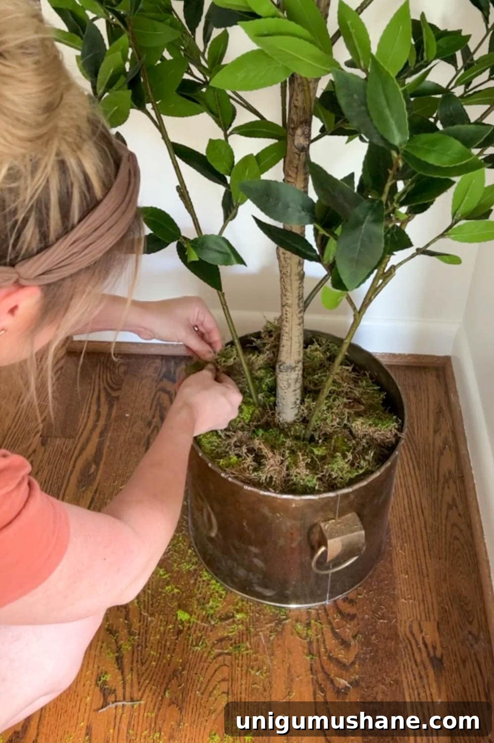 Make a Fake Tree Look Real: Lifelike Styling Tips 6 adding moss to a planter at the base of a faux tree