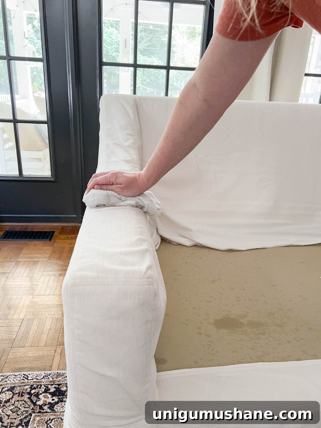 wiping up DIY couch cleaner on upholstery to clean a sofa
