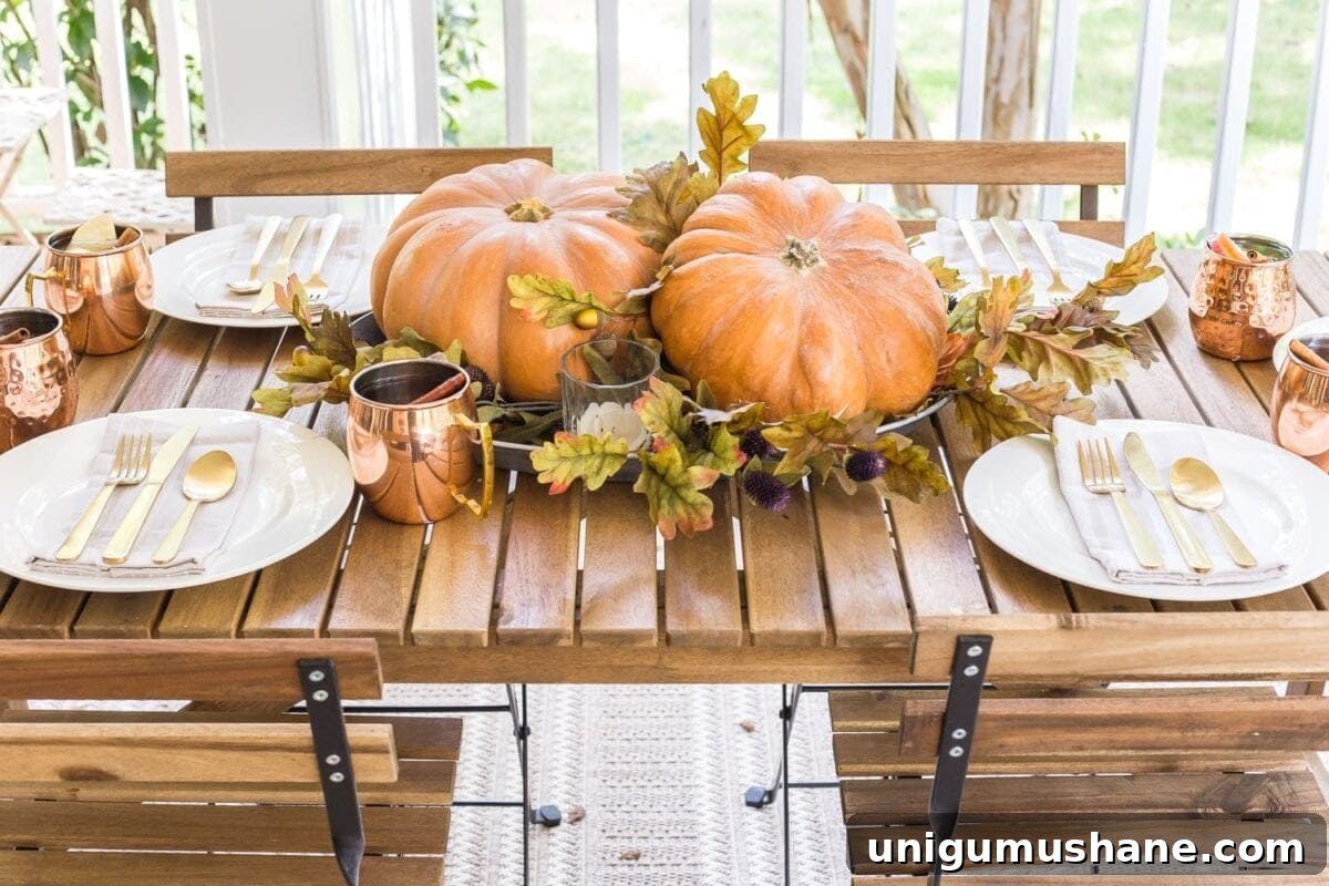 DIY Fall Centerpiece Ideas Using Autumn Branches 10 simple fall centerpiece made of a platter, leaves, and two pumpkins in the middle of an outdoor dining table