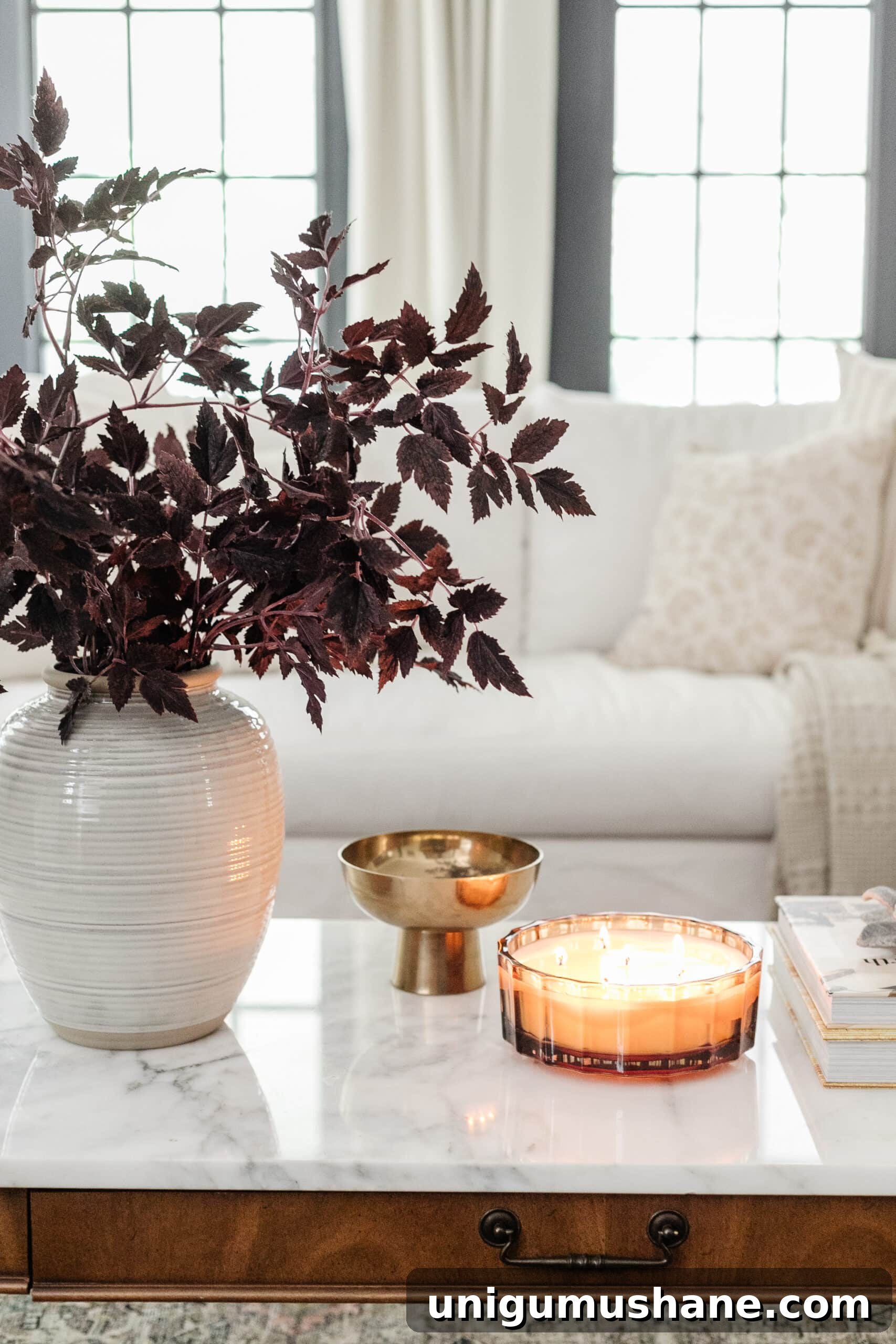 Budget Fall Living Room Decor Ideas That Save Time 14 fall decor on a coffee table with vase of fall branches, candle, brass bowl, and books