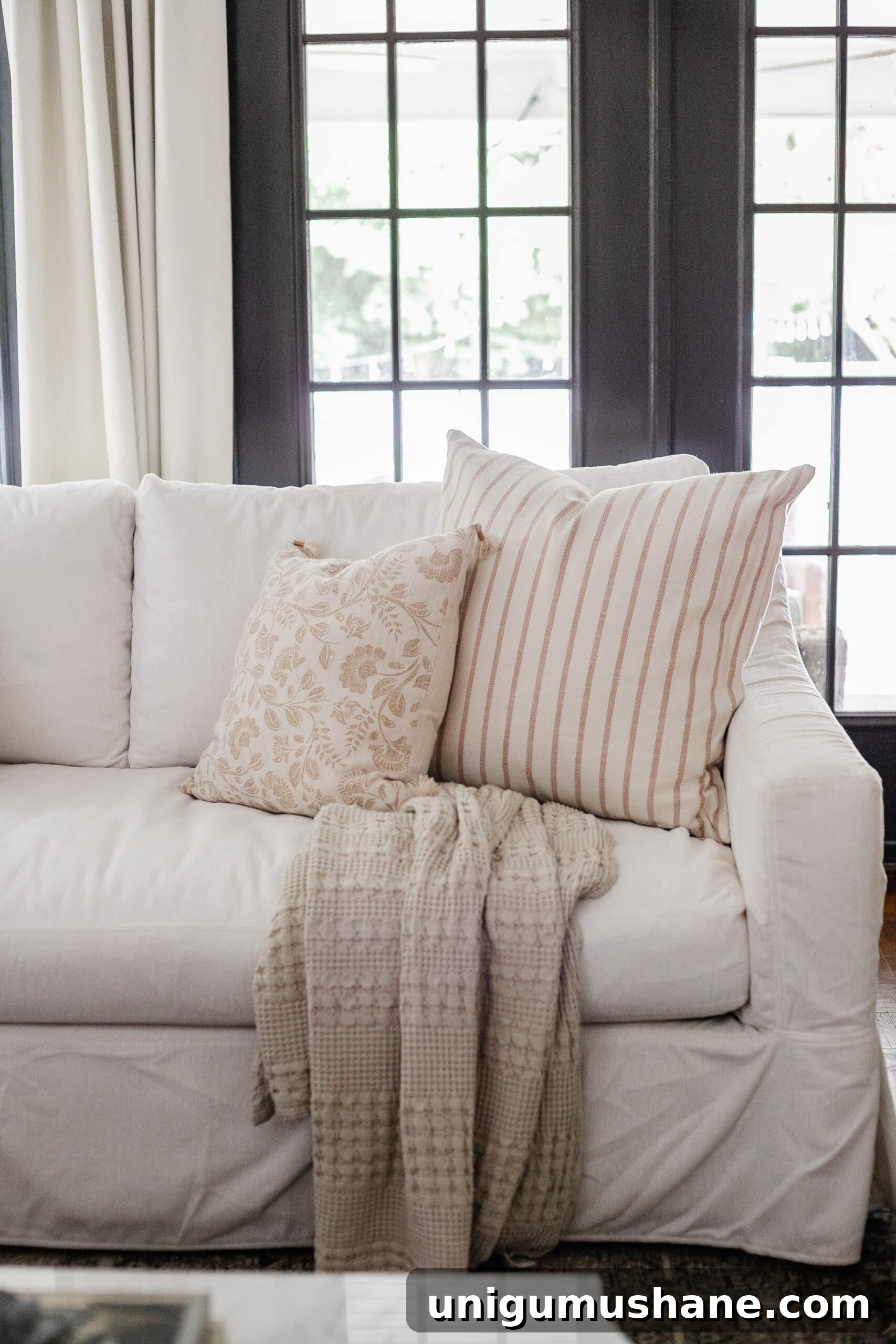 Budget Fall Living Room Decor Ideas That Save Time 10 neutral fall pillows on a white couch in a living room decorated for fall