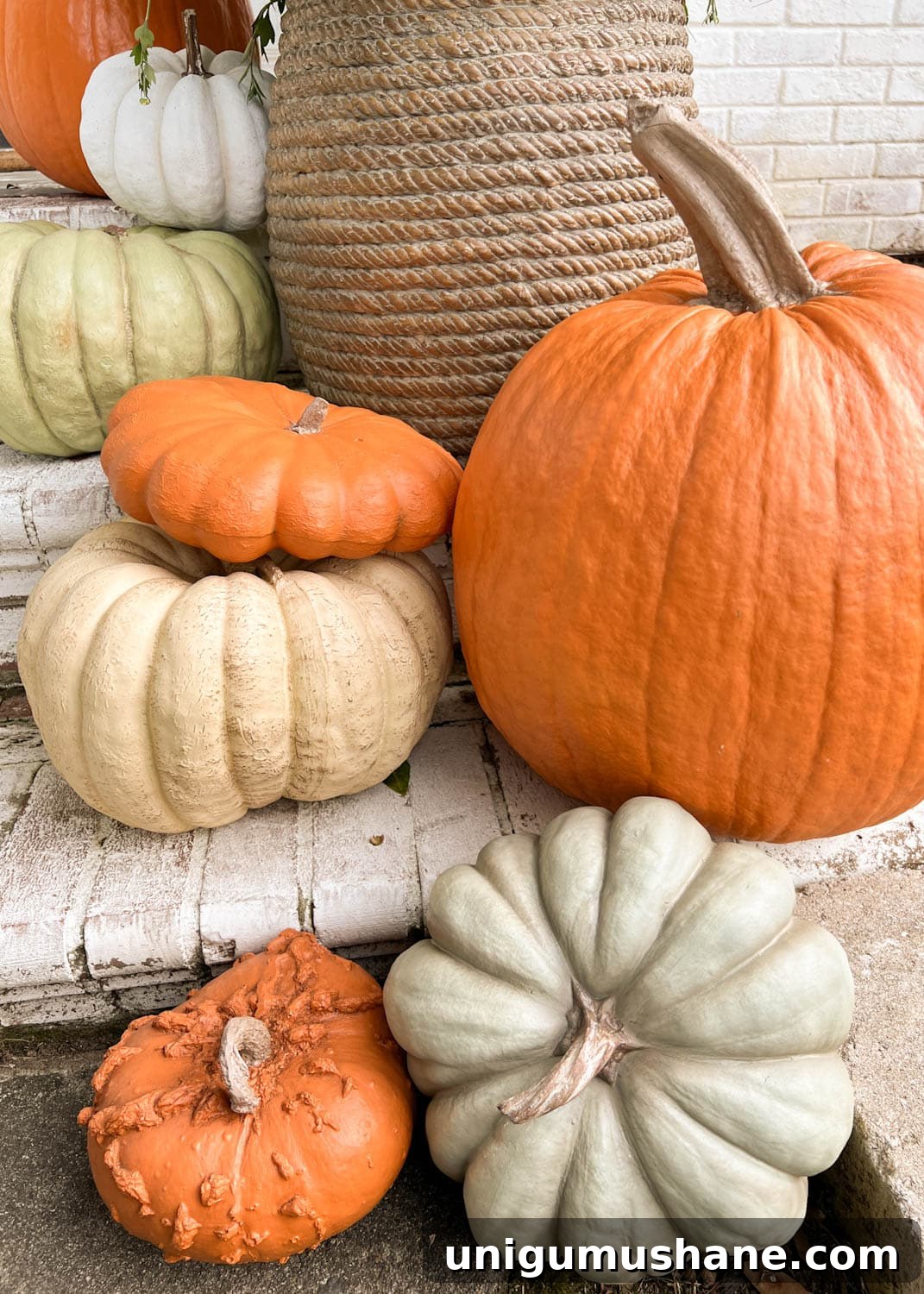 Realistic Faux Pumpkins for Fall 2024 Home Decor 3 realistic fake pumpkins on limewashed brick porch steps