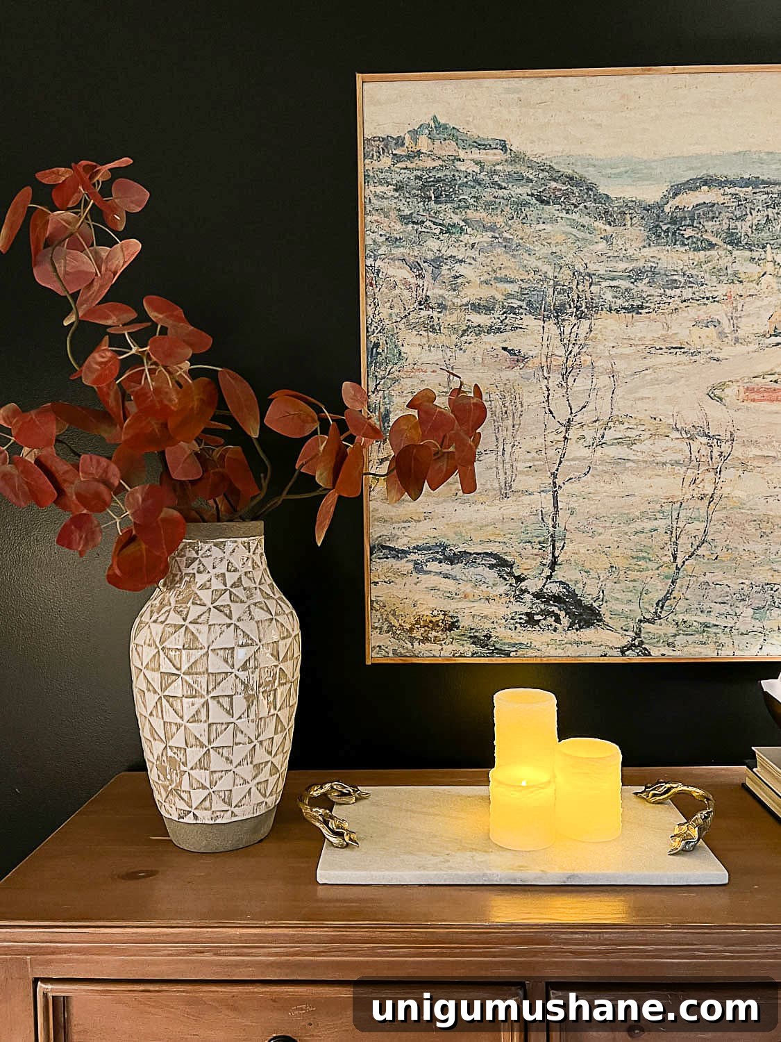 10 Affordable Cozy Bedroom Ideas to Improve Sleep 10 flameless candles, marble tray, vase of fall branches and large wall art on top of dresser