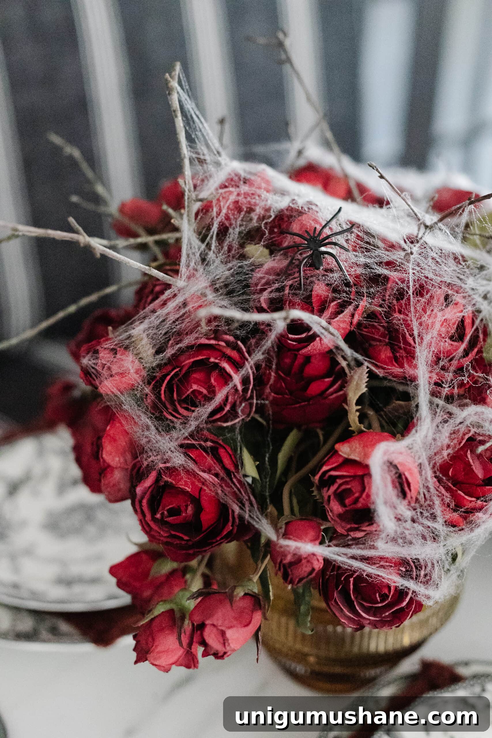 Murder Mystery Party Table Decor Ideas for Halloween 7 vase of red roses with spider webs for a simple Halloween flower arrangement