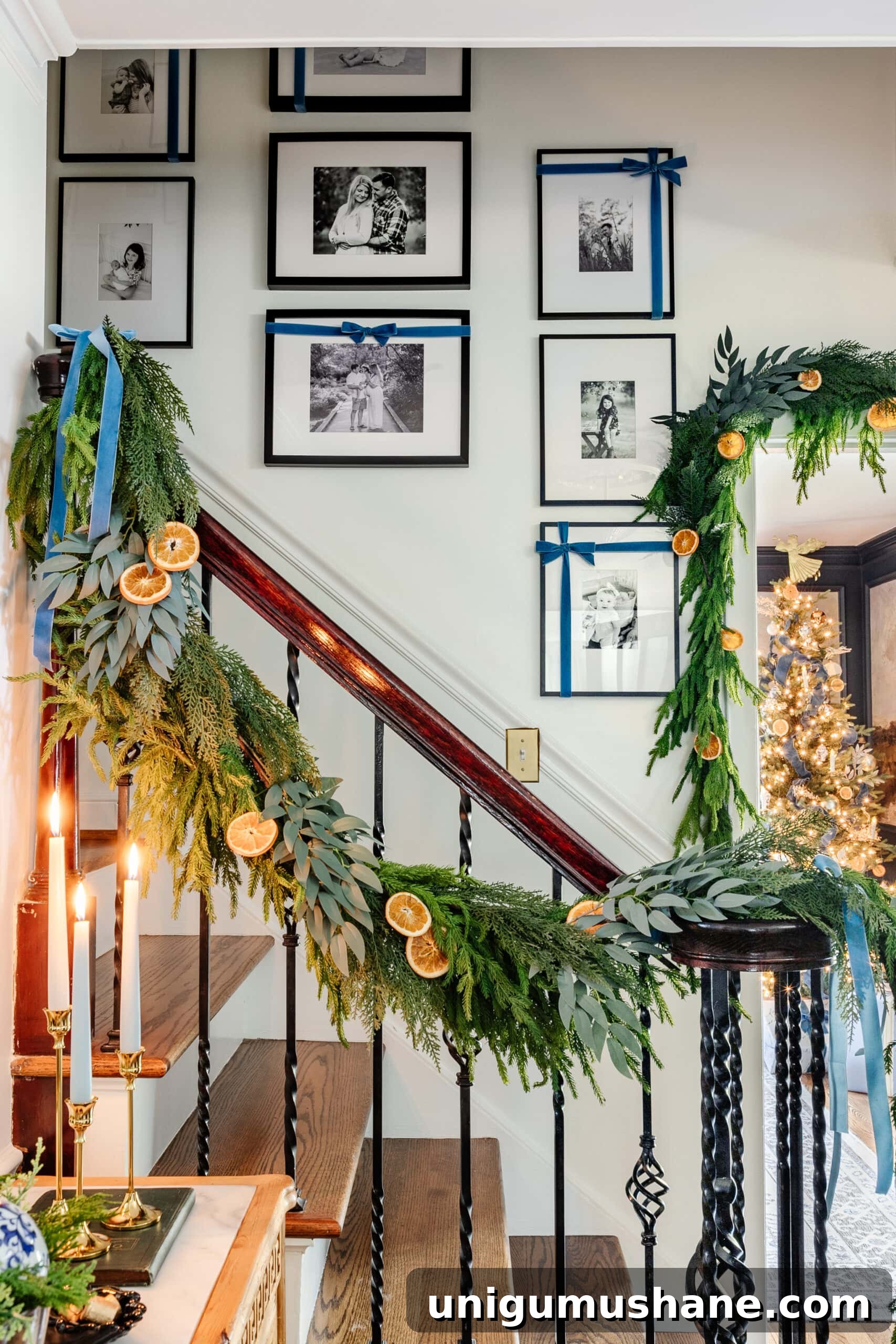 family photo gallery wall with Christmas bows going up a staircase