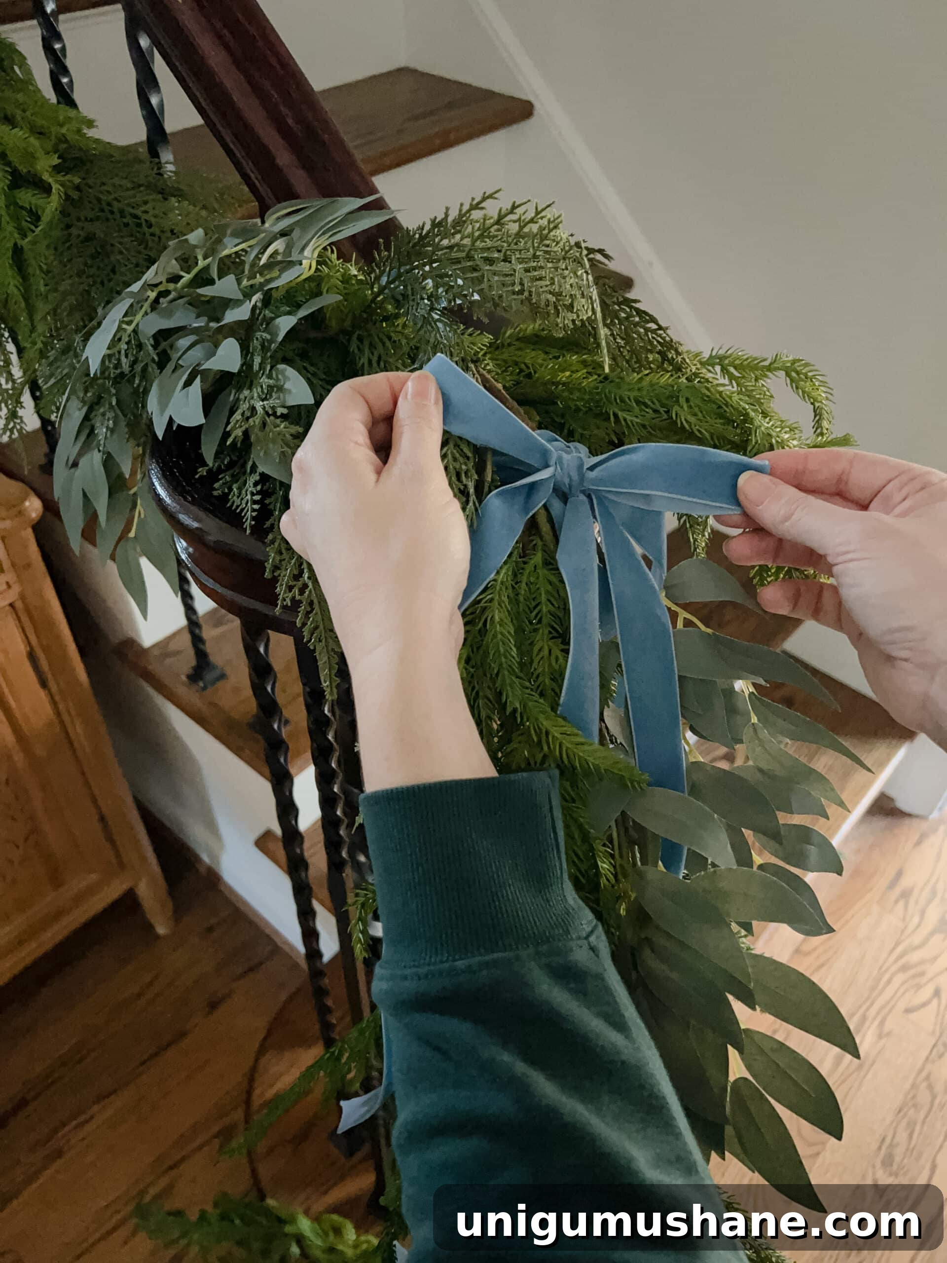 adding bows to staircase garland