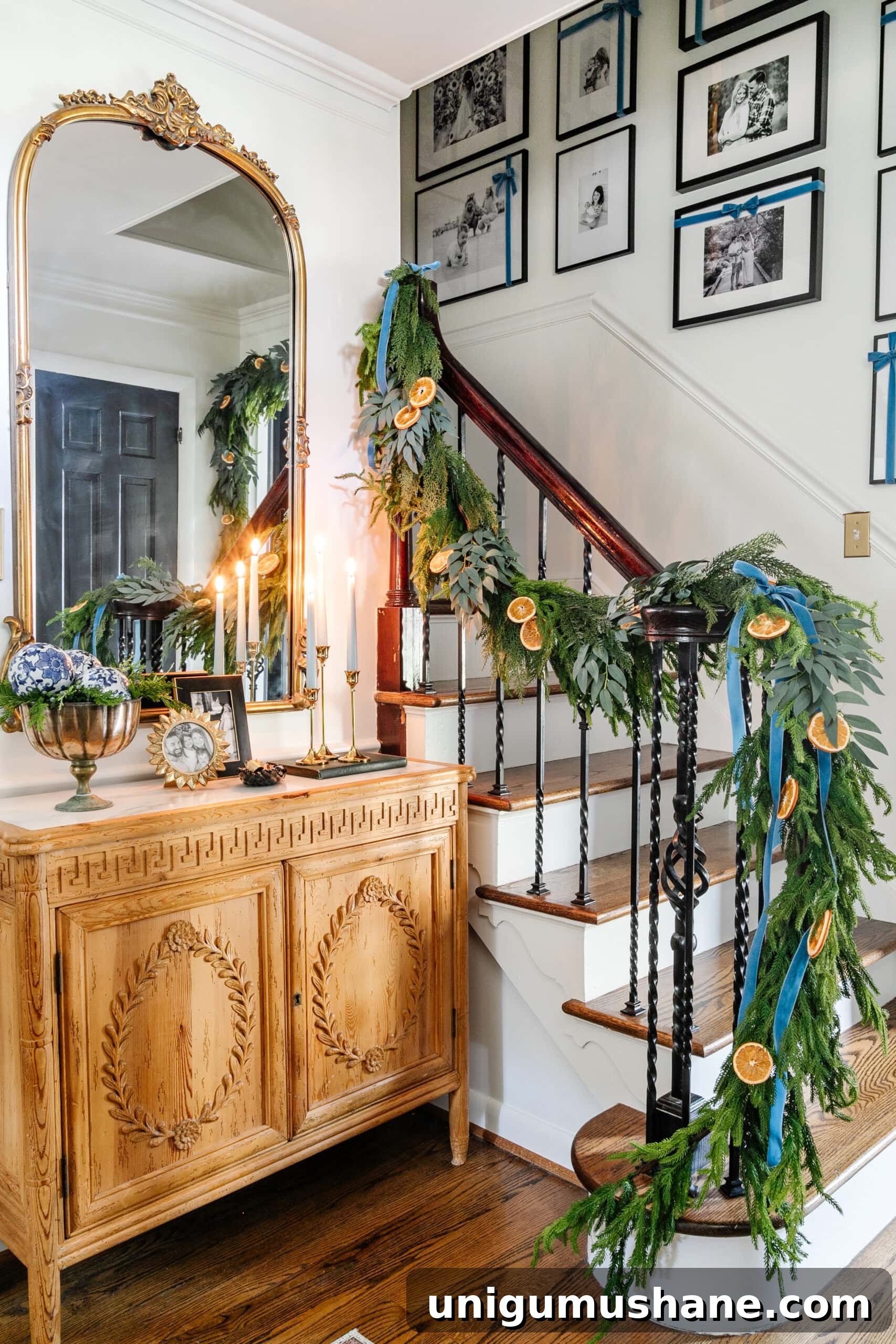blue entryway Christmas decor with ribbon hanging from garland on stairs