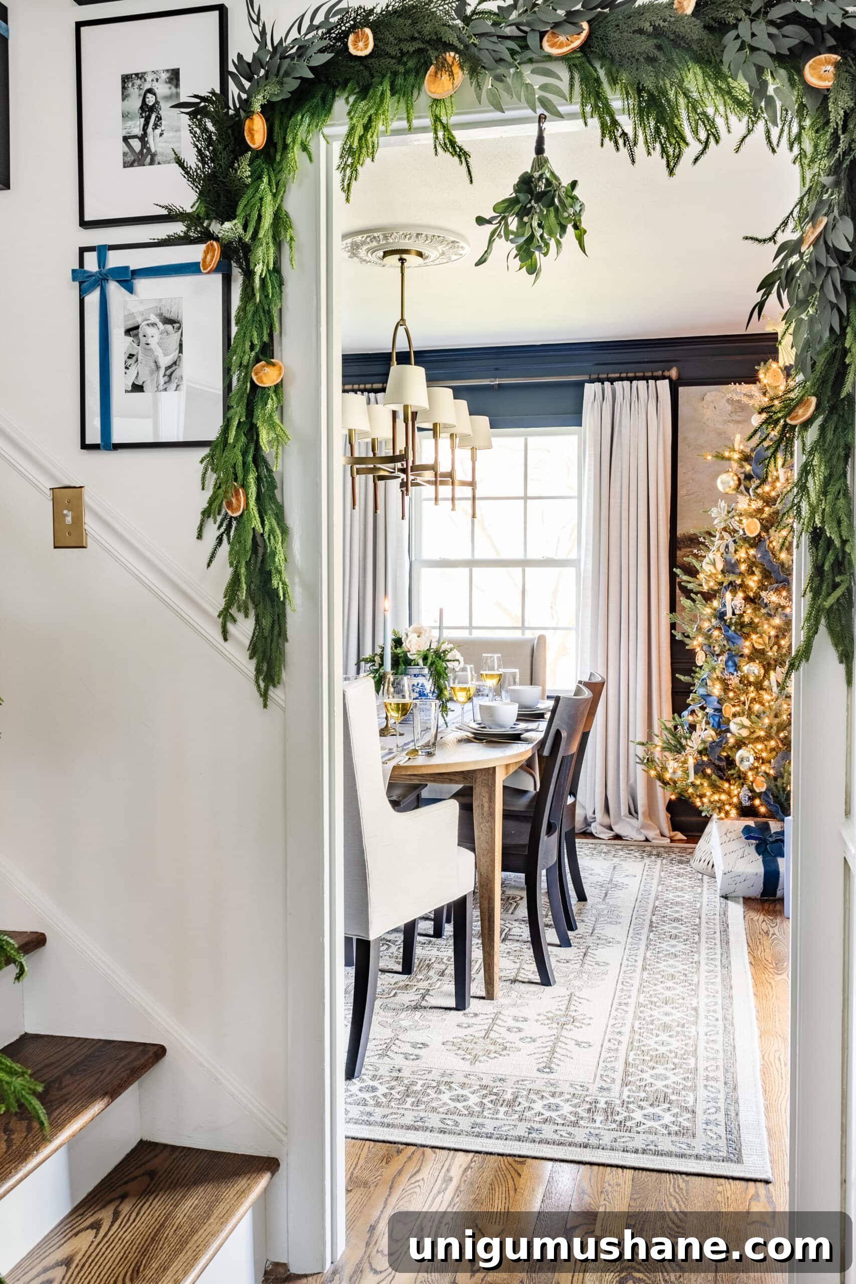 peek of dining room Christmas tree with garland framing doorway