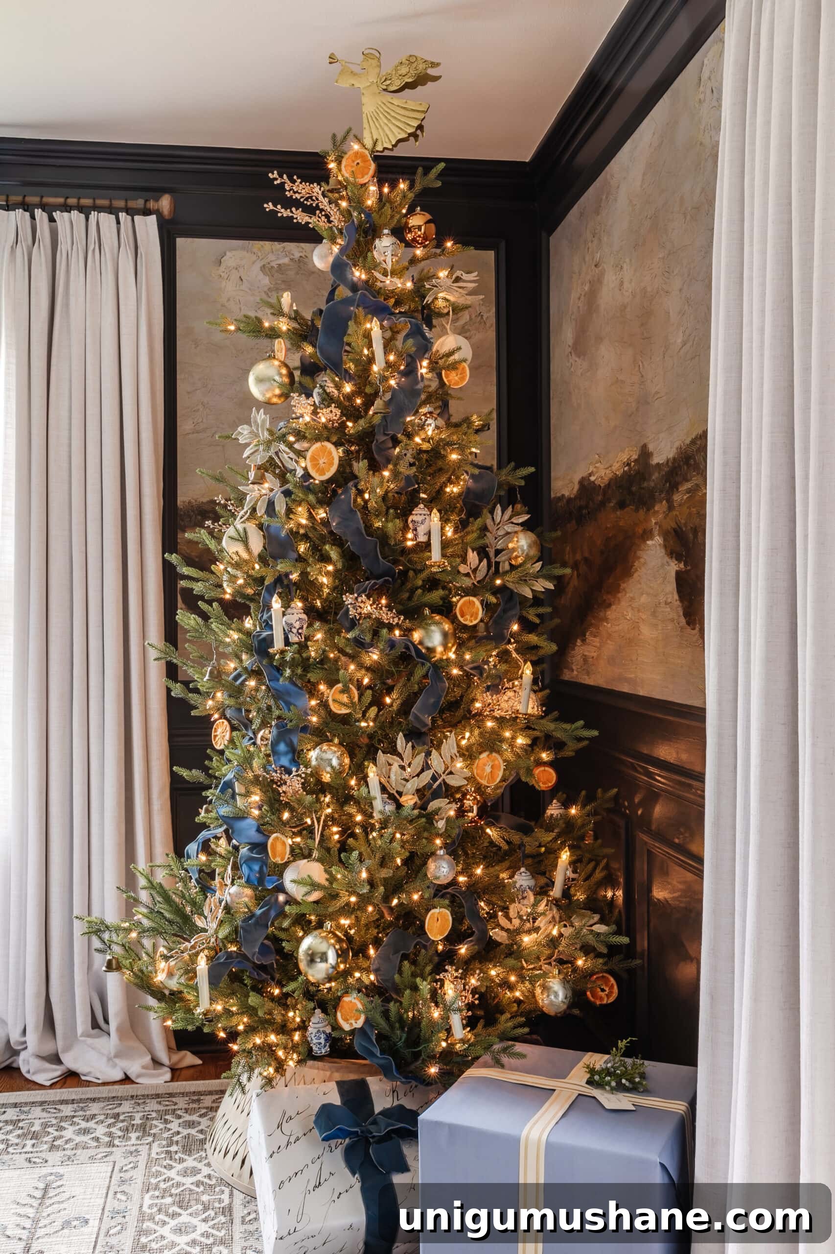 blue Christmas tree decor with ribbon, metallic ornaments, and white and blue ornaments