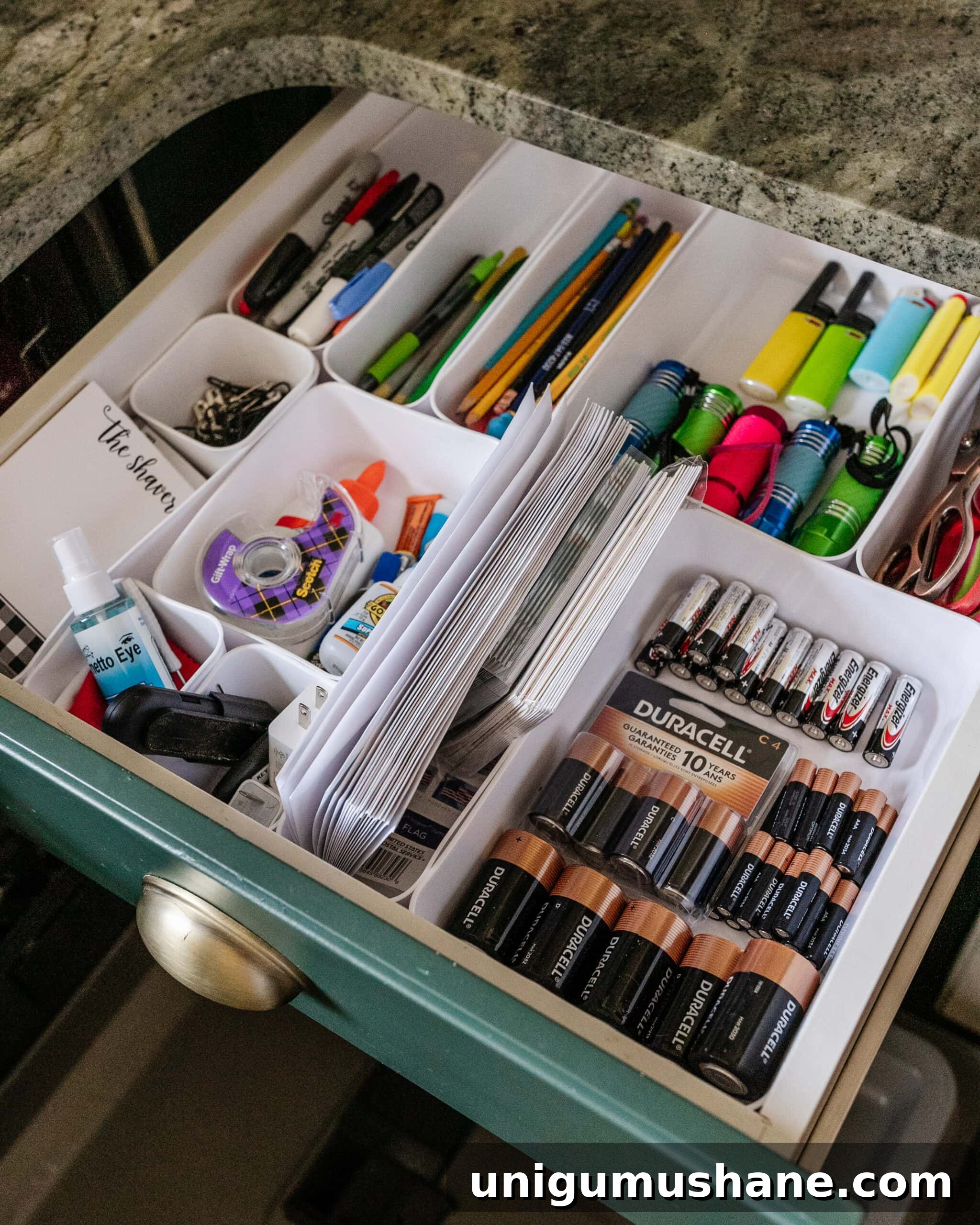 14 Things to Declutter for the New Year 9 junk drawer organization with batteries, pens, flashlights, lighters, scissors, glue, and tape