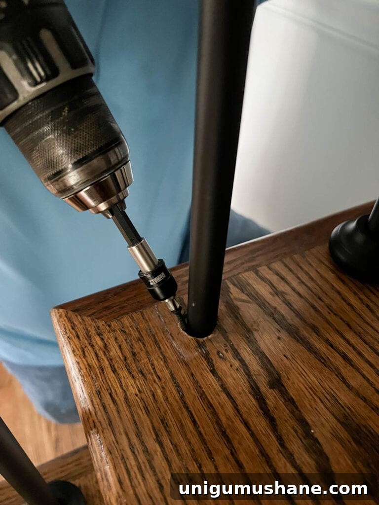 Replace Stair Spindles: DIY Staircase Makeover Guide 22 drilling screw in stair tread to secure stair baluster