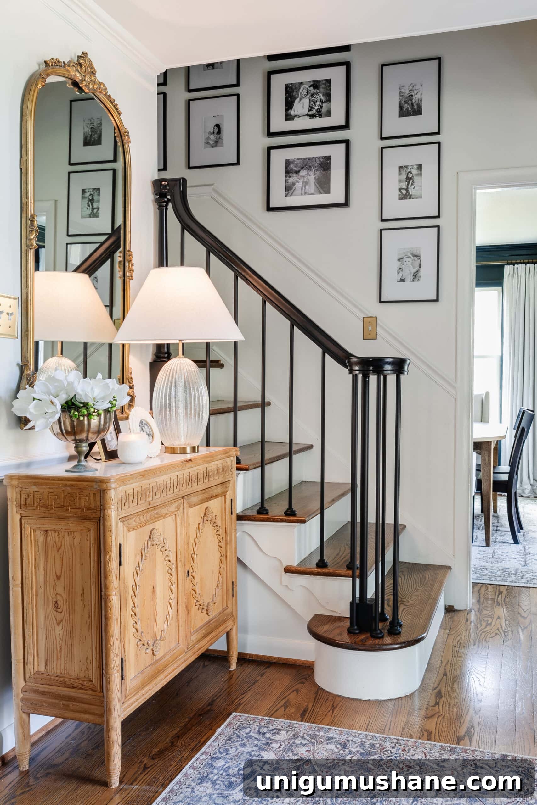 Replace Stair Spindles: DIY Staircase Makeover Guide 26 classic foyer with carved wood credenza, black stair railing, and family gallery wall on stairs