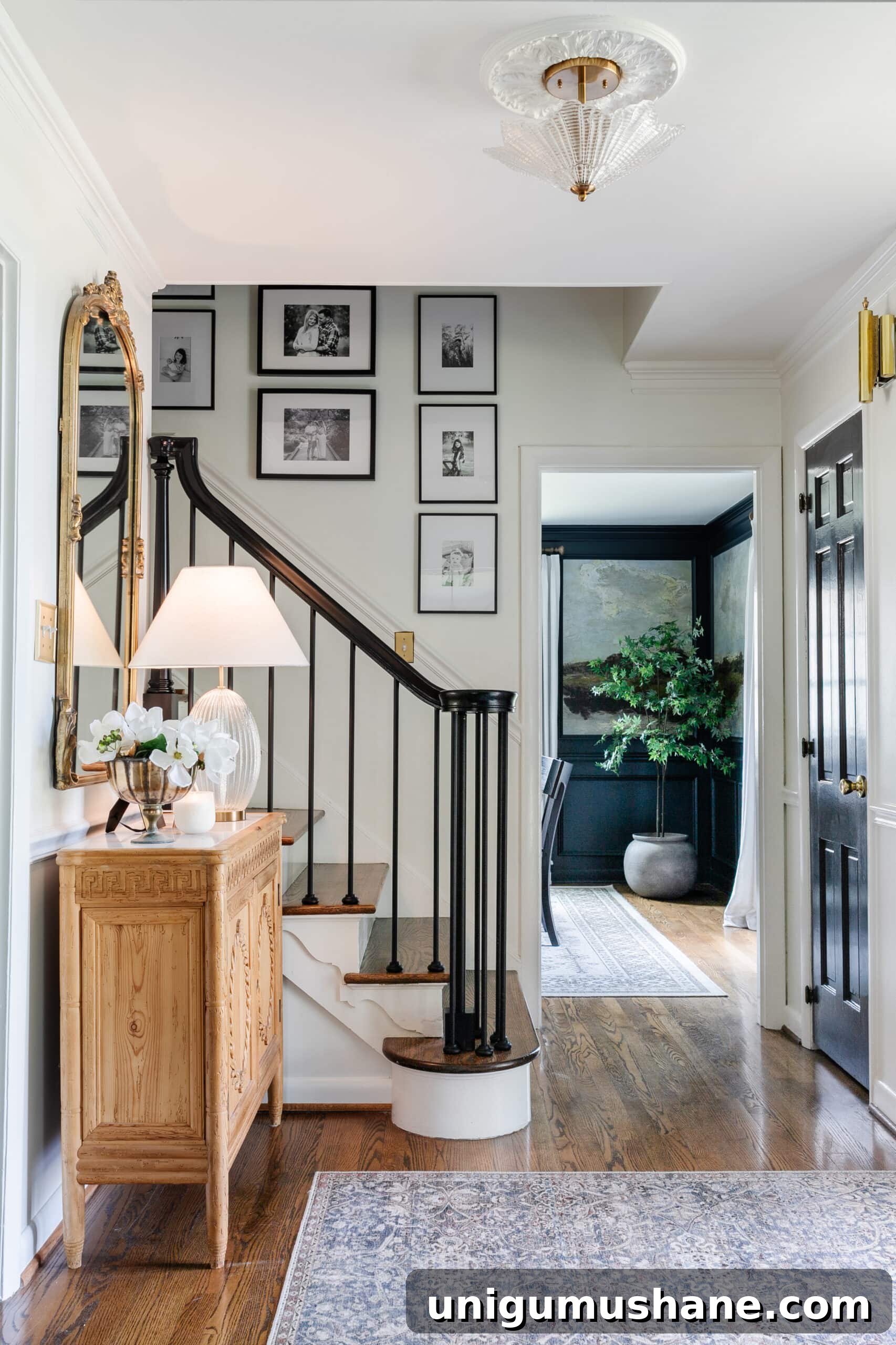 Replace Stair Spindles: DIY Staircase Makeover Guide 28 classic foyer with carved wood credenza, black stair railing, and family gallery wall on stairs