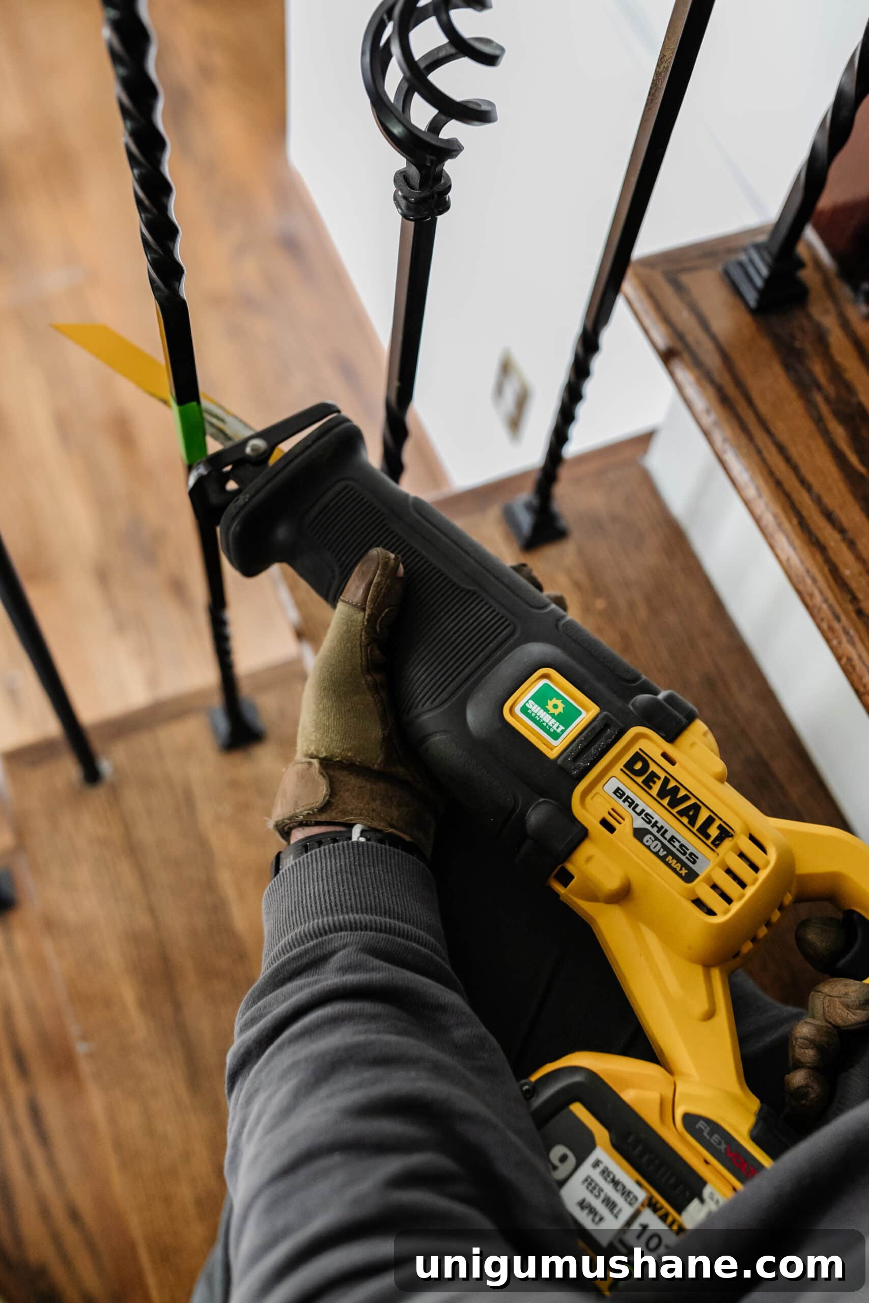 Replace Stair Spindles: DIY Staircase Makeover Guide 7 close up of cutting wrought iron stair balusters with a reciprocating saw