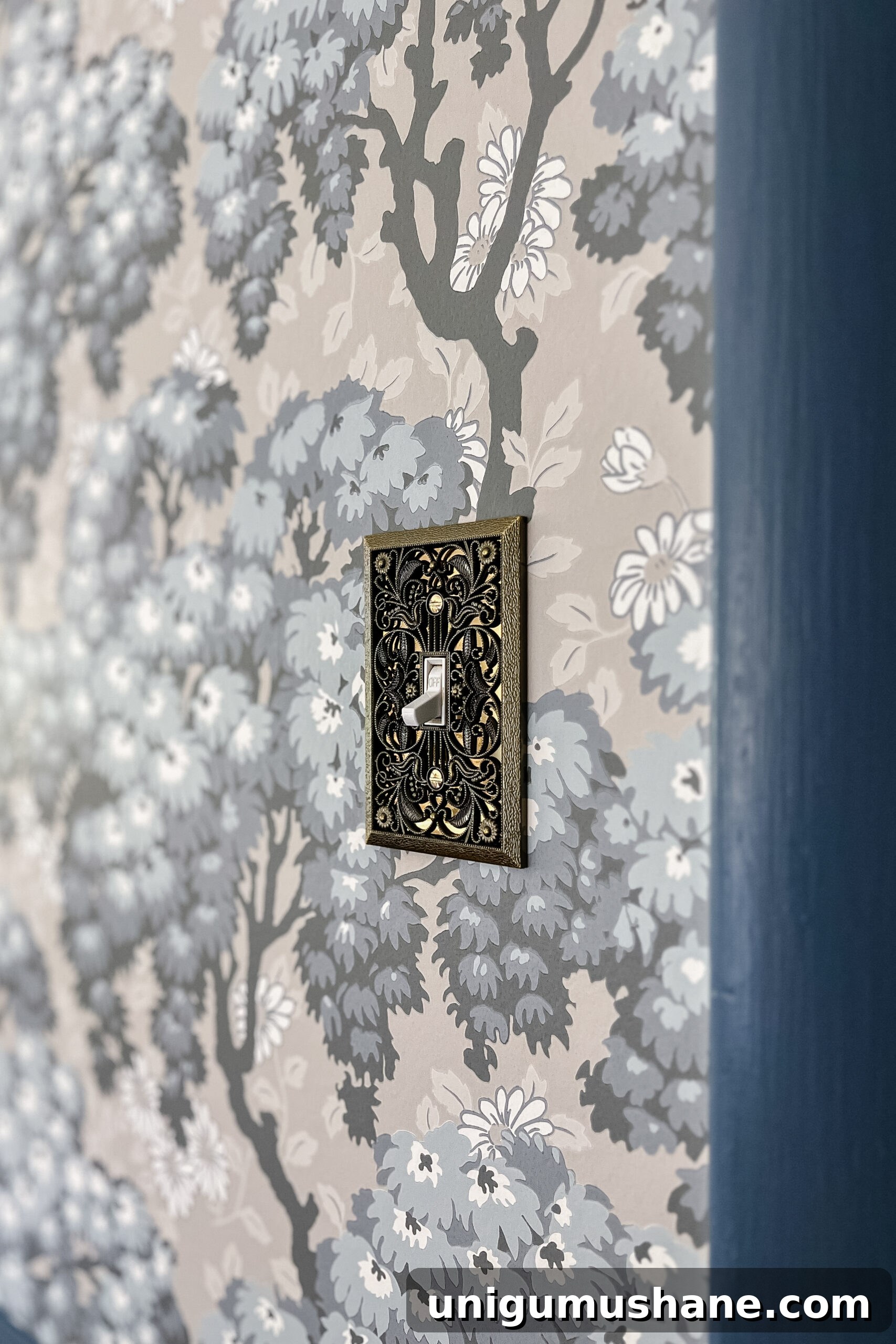vintage light switch cover on floral swedish wallpaper 