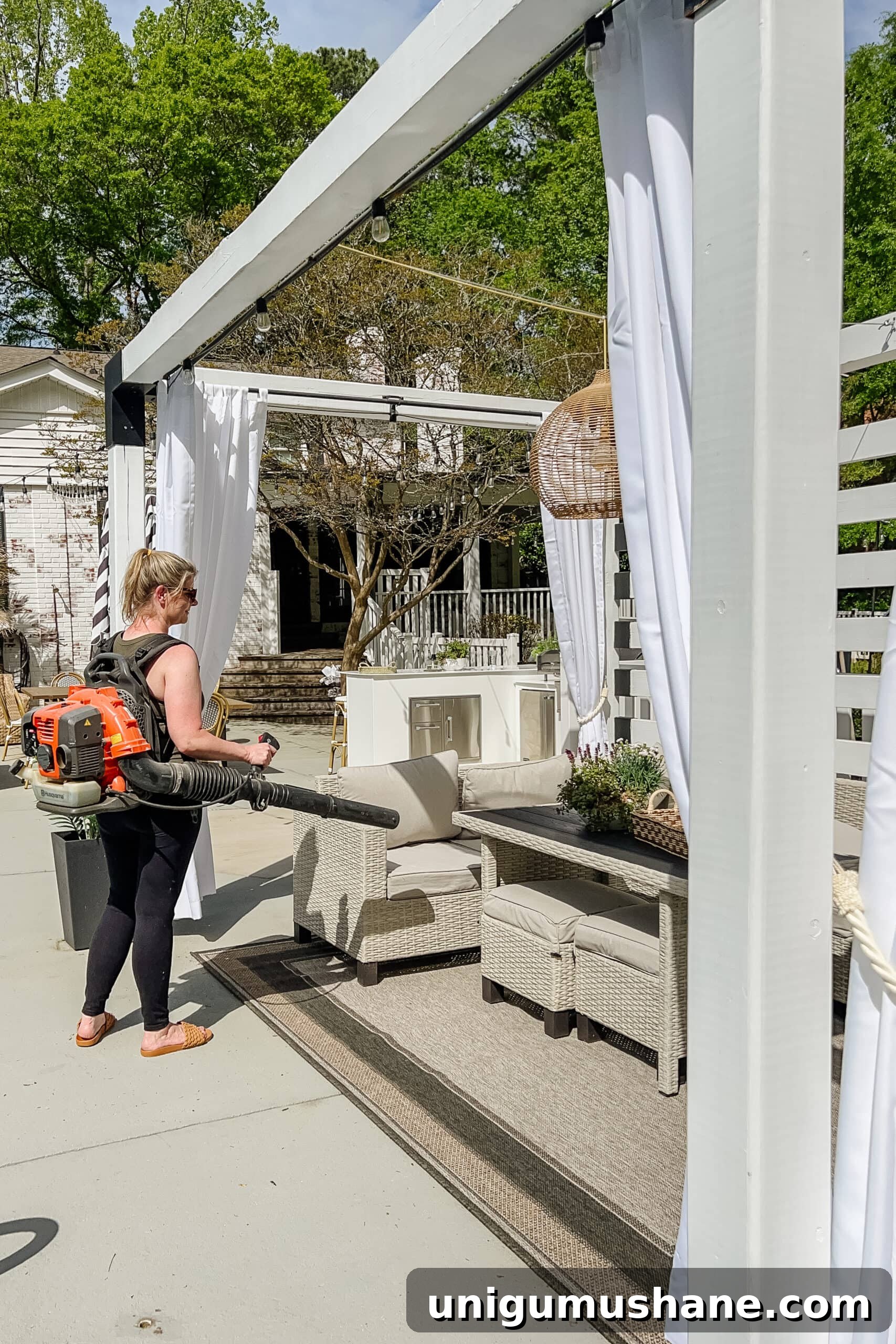 Spring Cleaning Checklist for Your Backyard Patio 15 cleaning debris on a patio using a leaf blower