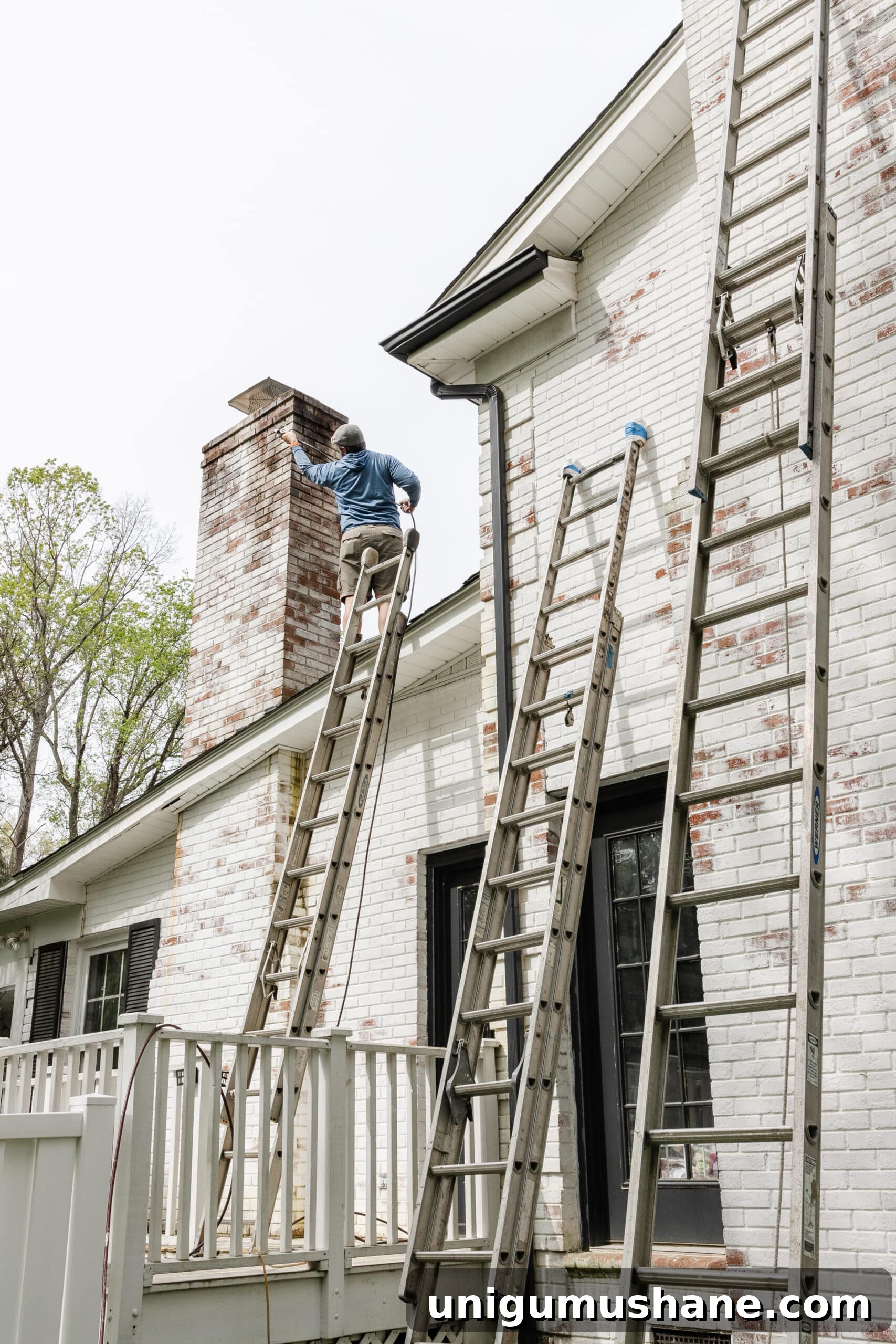 Limewashed Brick Cleaning and Maintenance Guide 8 contractor on ladder cleaning limewashed chimney