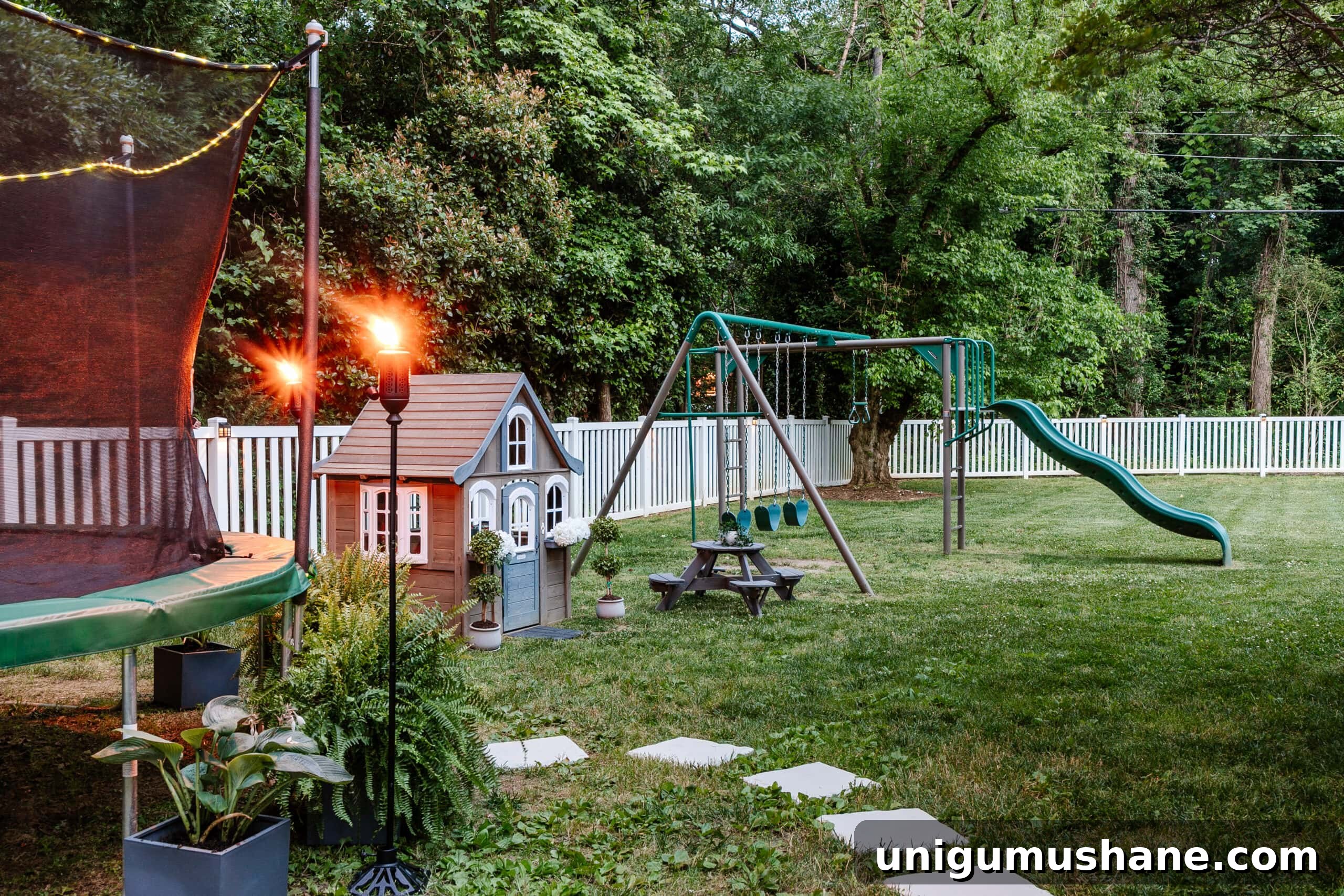8 Side Yard Play Area Ideas and Trampoline Decor Tips 4 stepping stones leading to outdoor trampoline with tree stump trampoline ladder, ferns, tiki torches, playhouse, picnic table, and swing set