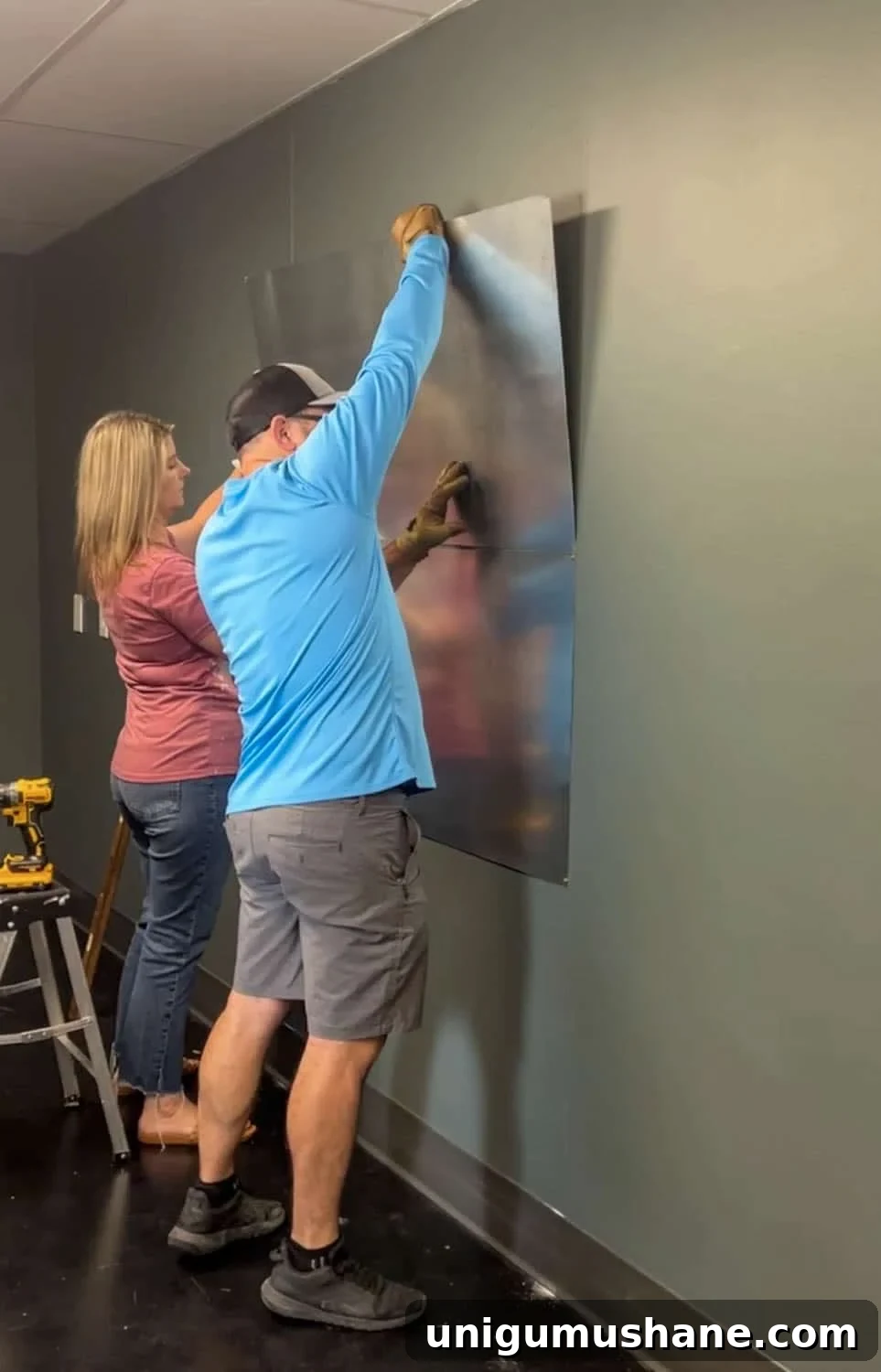 placing metal sheets on a wall to make a magnetic notice board