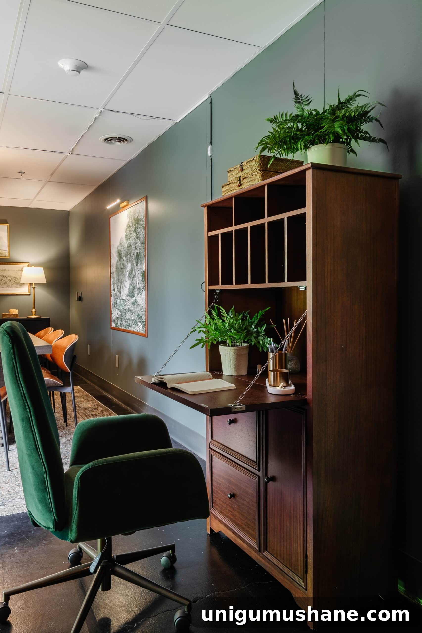wooden secretary desk and green desk chair in an office