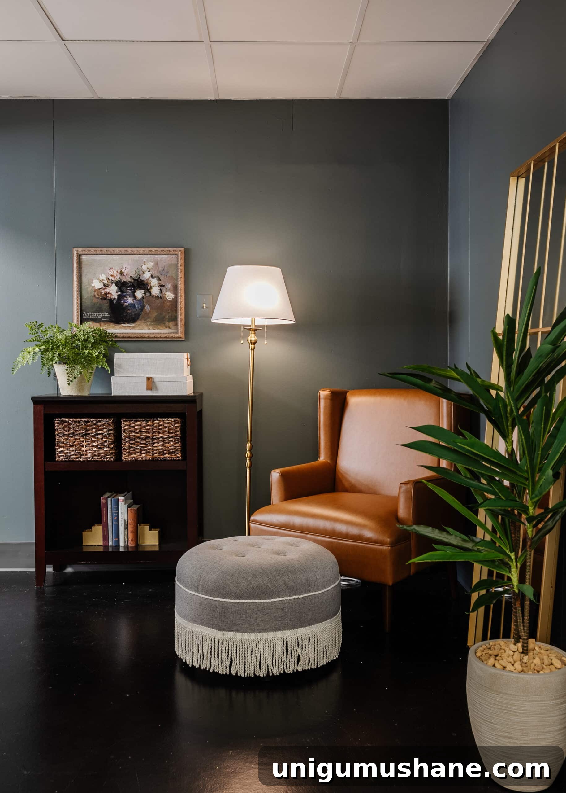 leather armchair and gray fringe footstool in a reading corner in an office